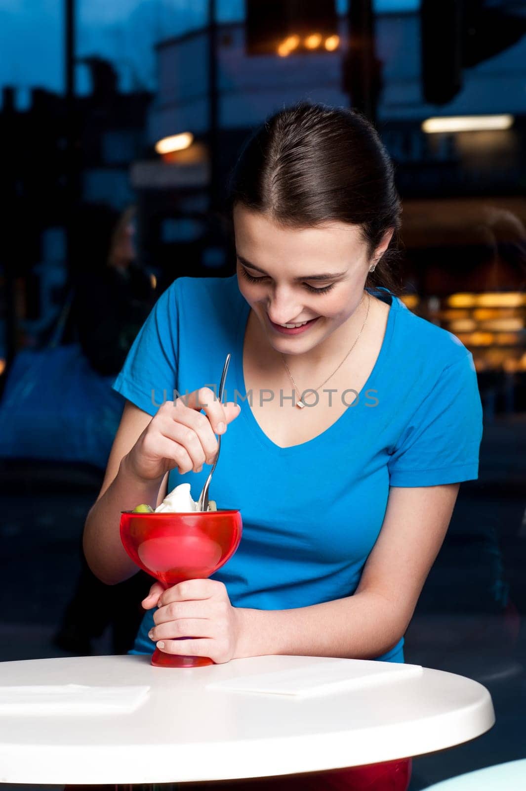 Attractive young girl enjoying ice cream with toppings