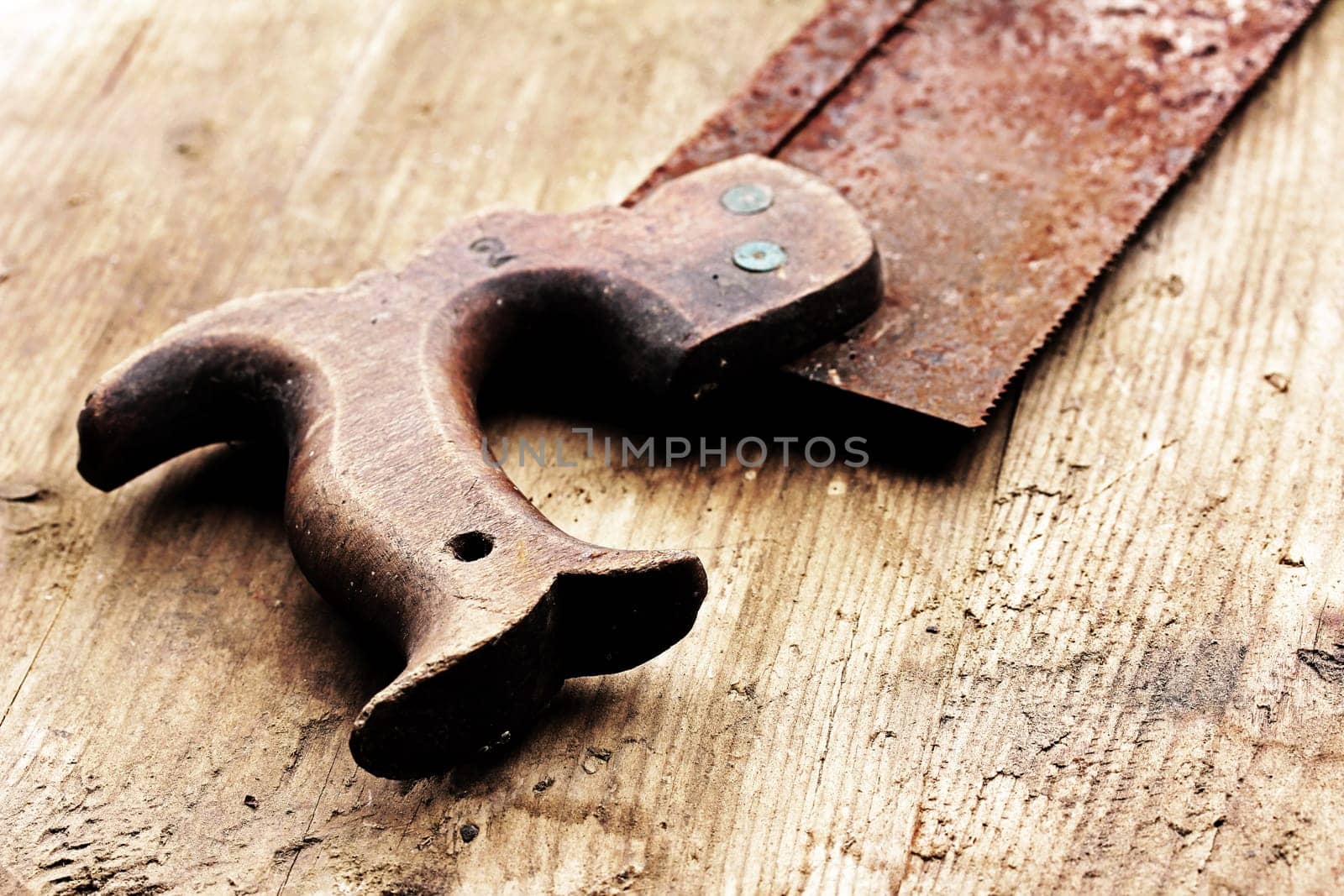 An old rusty saw on a wooden table