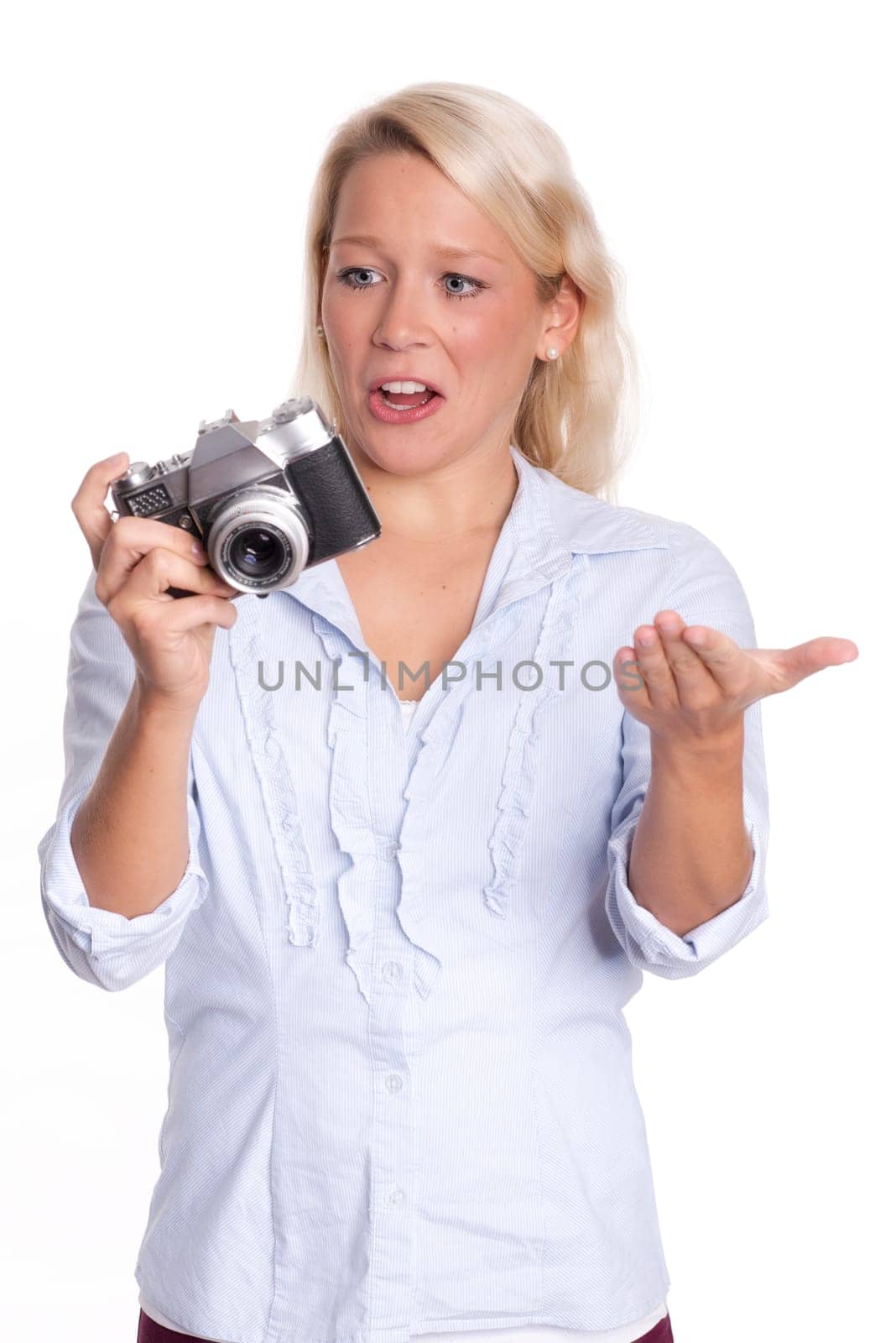 Young woman with analog camera looks skeptical