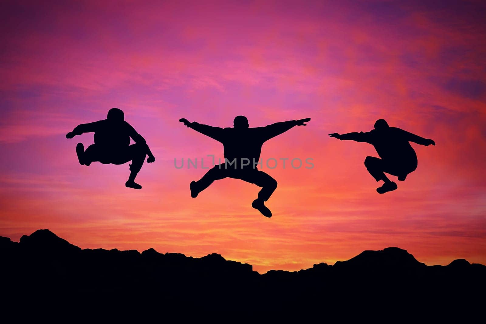 Three boys jump over a mountain sunset