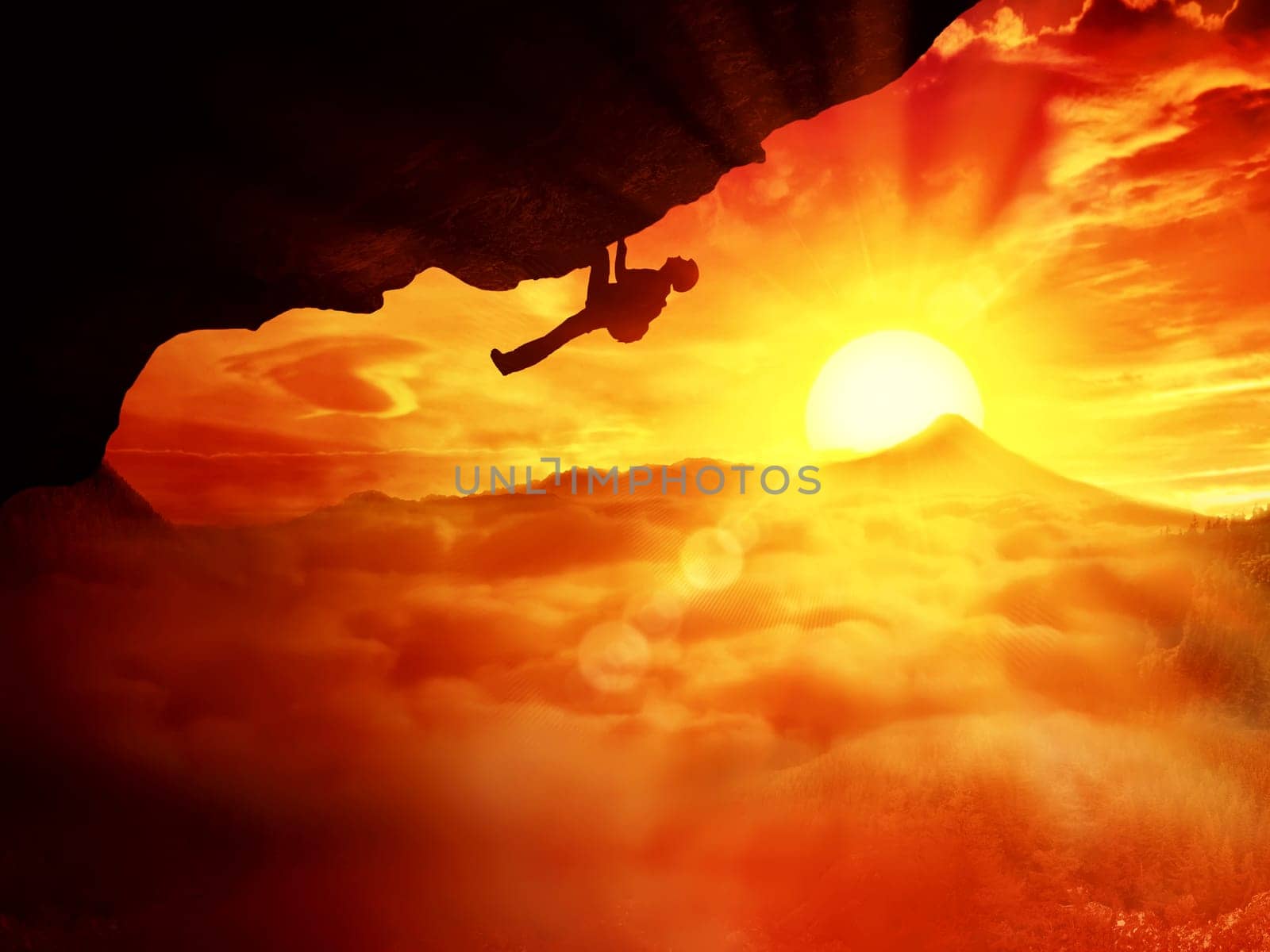 Beautiful background with an alpinist trying climb a mount over the clouds sunset
