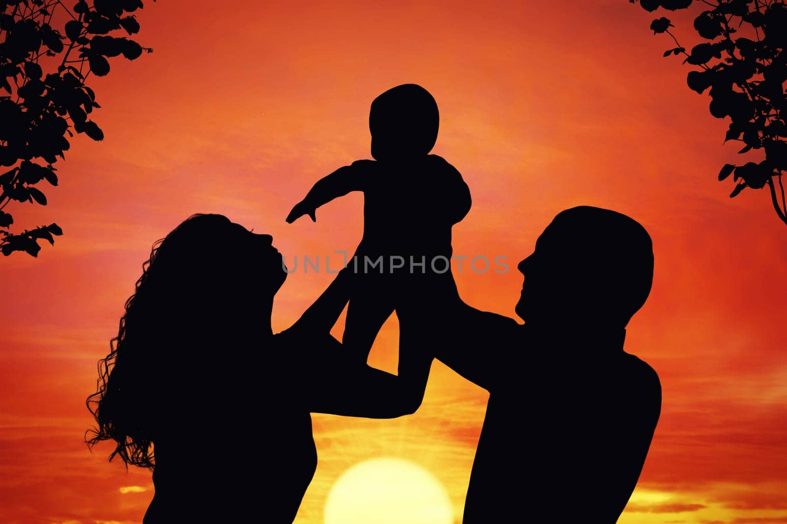 Parents with their little child at sunset, raising baby up in the air. Silhouette of a happy family of three people, mother, father and baby