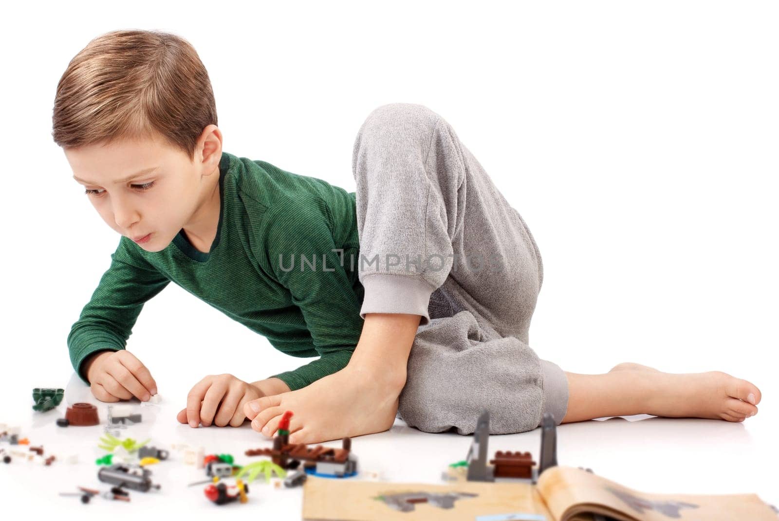 Handsome guy who is playing and building something from book