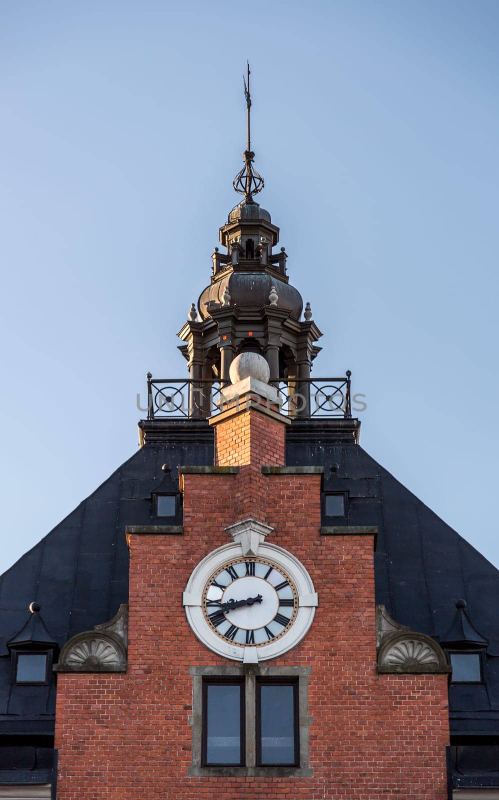 The Town House Clock and Steeple in Umeå, Sweden with a clear blue sky behind it.