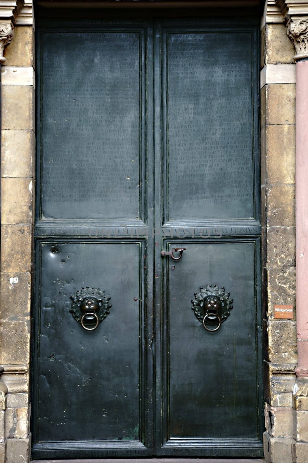 Mainz,Germany – September 04,2015: The heavy iron door of the entrance to Mainz Cathedral with engraved Latin words on September 4,2015 in Mainz.