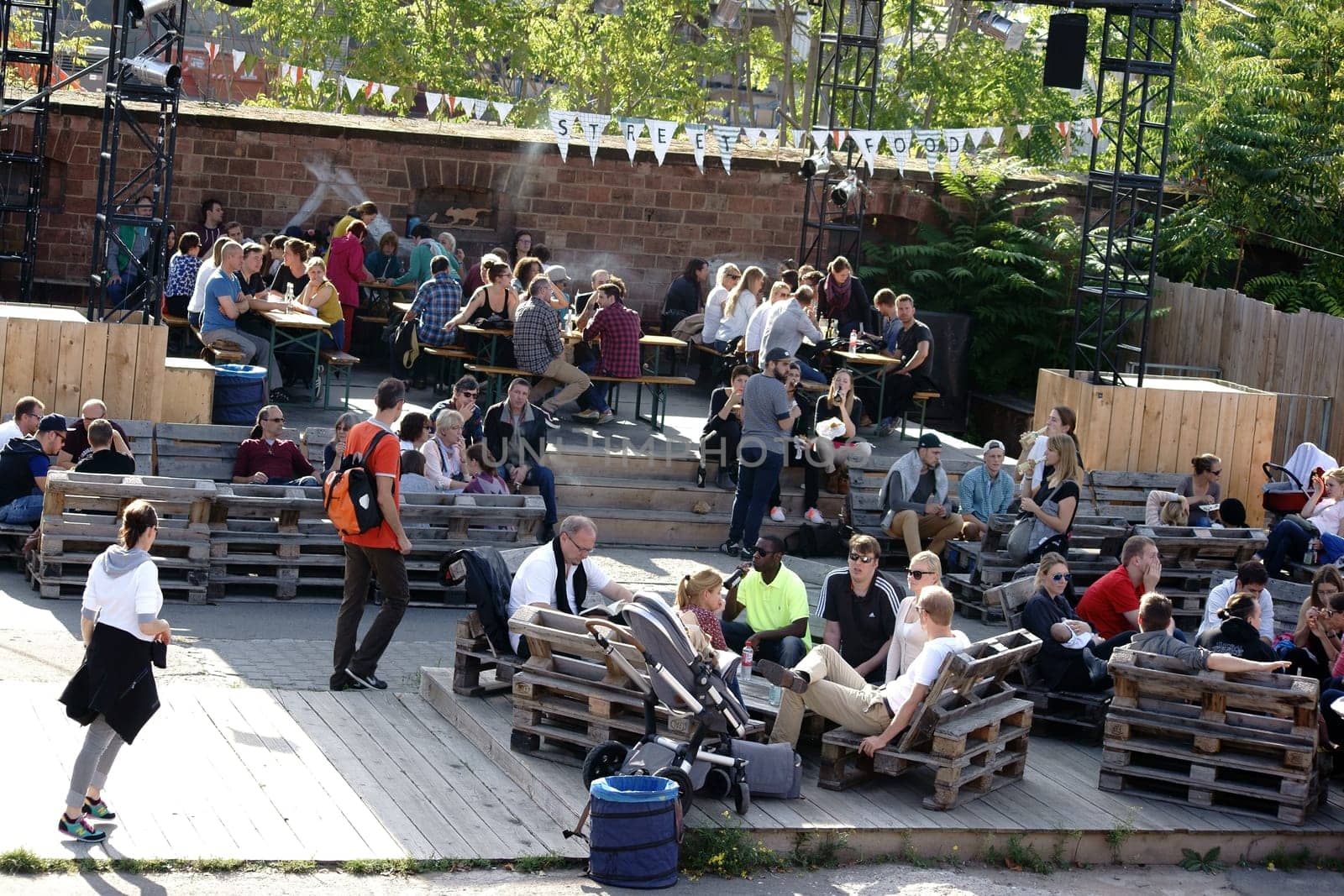 Mainz,Germany - October 02,2015: Young people,spectators and visitors sit on wooden pallets and at beer tables at the Streefood Festival on October 2,2015 in Mainz.