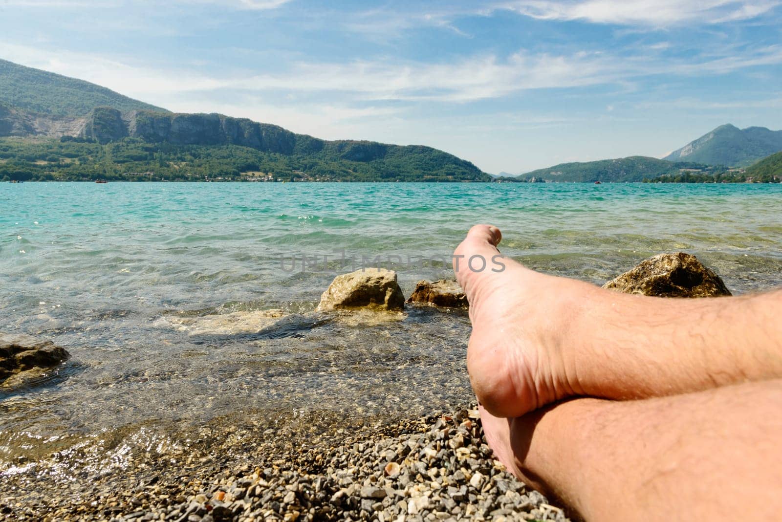feet of man on the beach of lake of Annecy