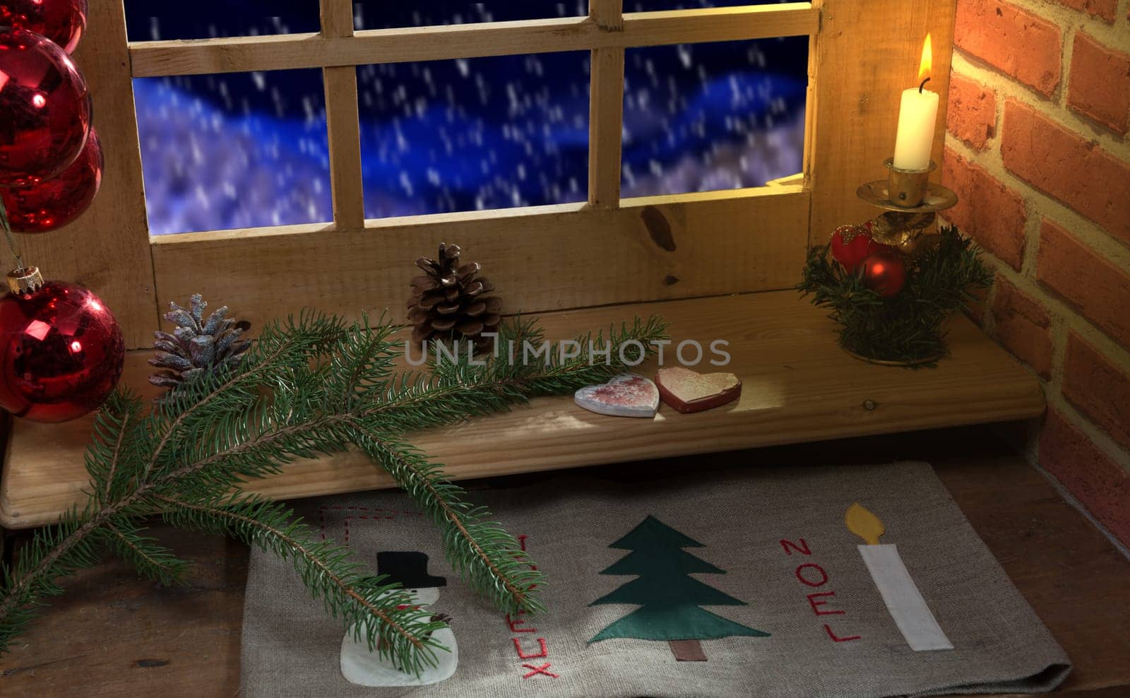 Close up of a window, decoration christmas,  candle and snow outside.