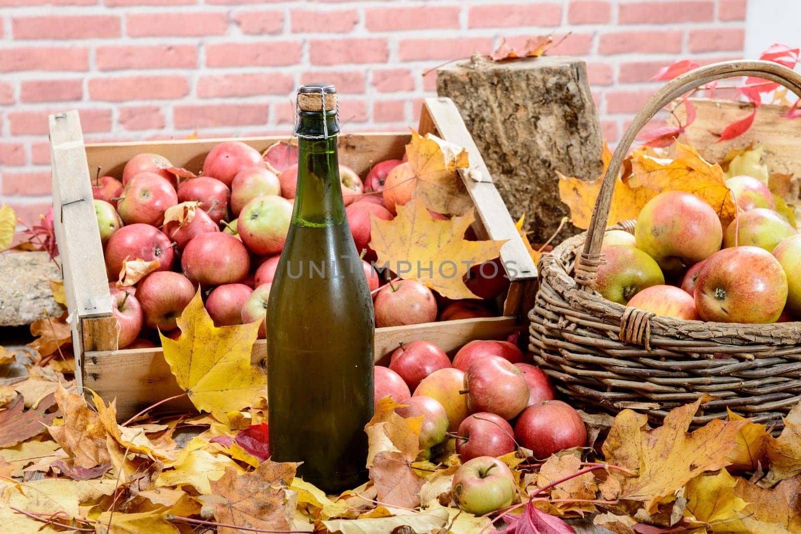 a bottle of Normandy Cider, with many apples and basket