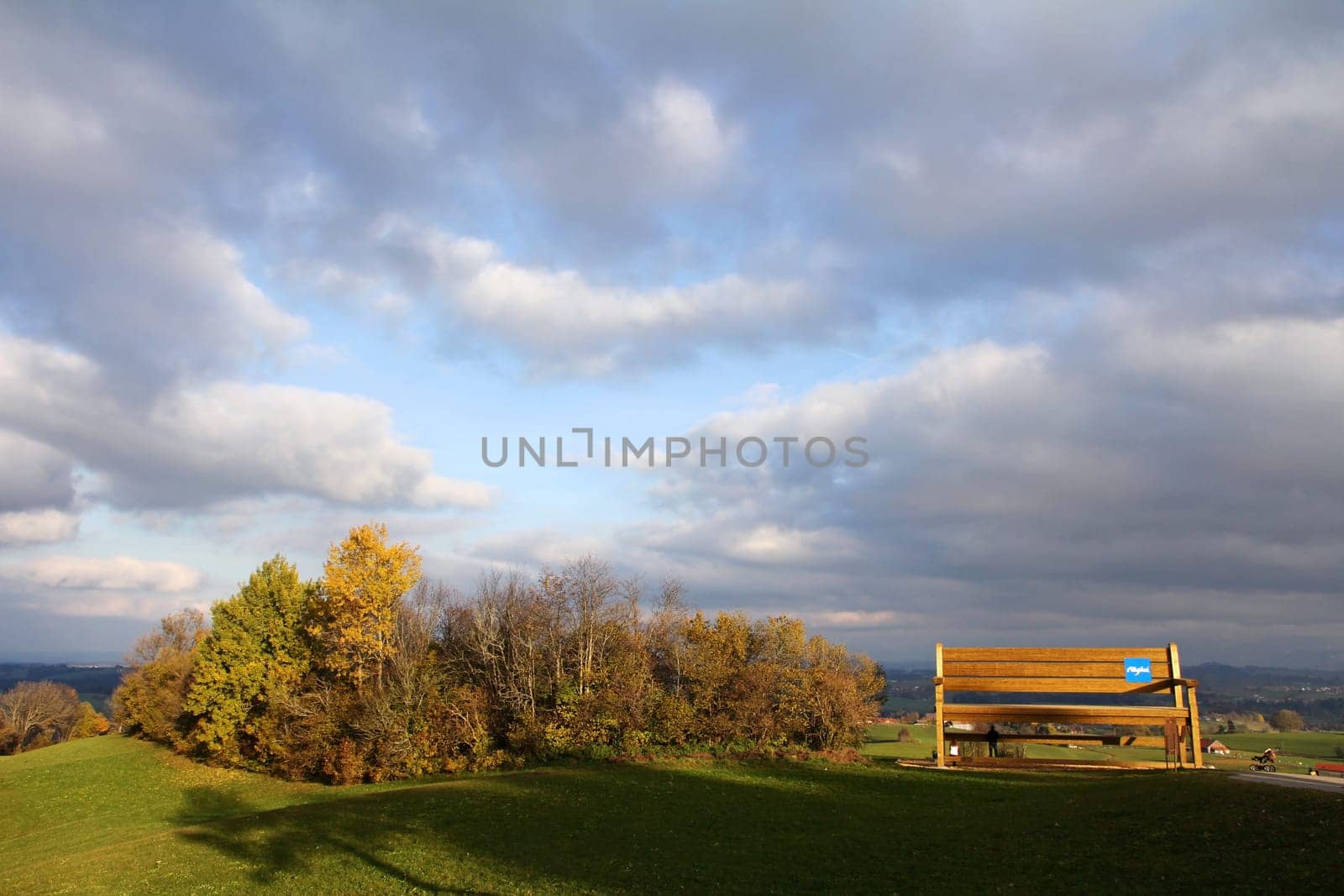 Autumnpanorama with a large wooden bench in the Allgäu