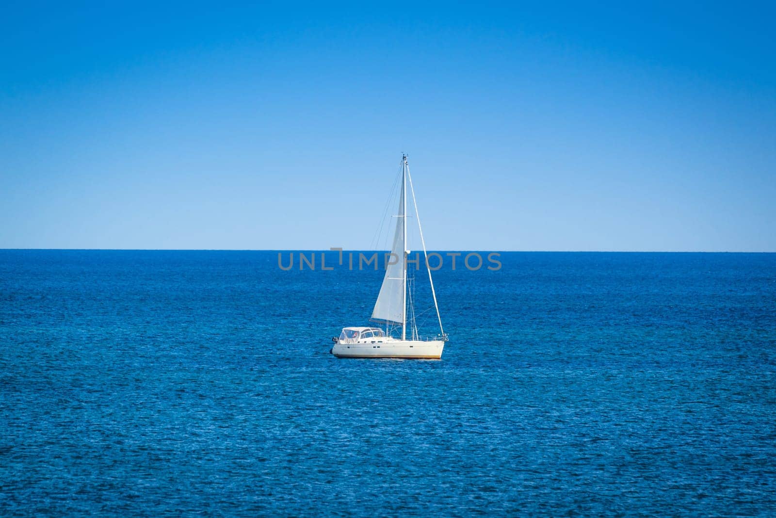Small sailboat on the blue ocean in daylight