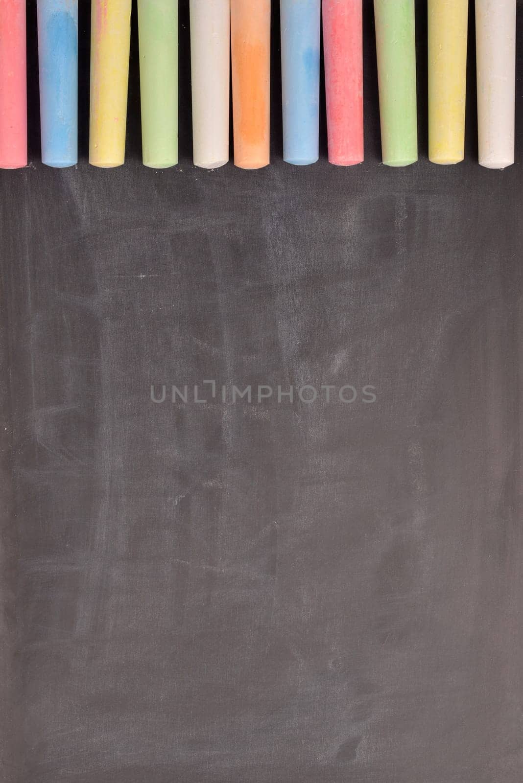 Colorful chalk on a blackboard with space for text or image