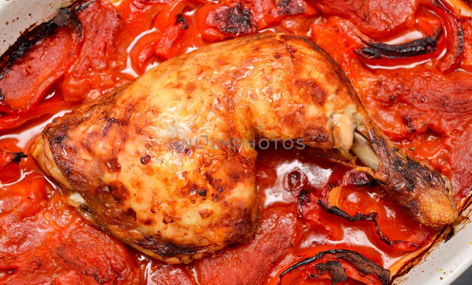 Roasted spicy chicken with tomatoes , red pepper and hot chili