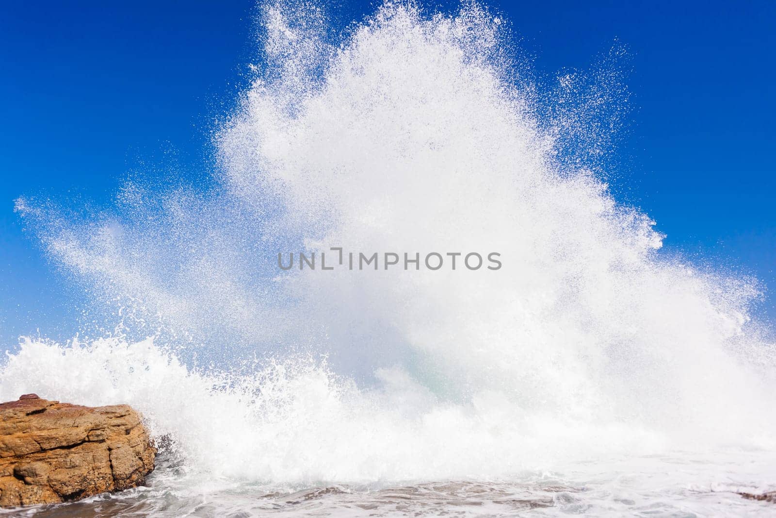 Ocean wave crashing rocky shoreline exploding white water power