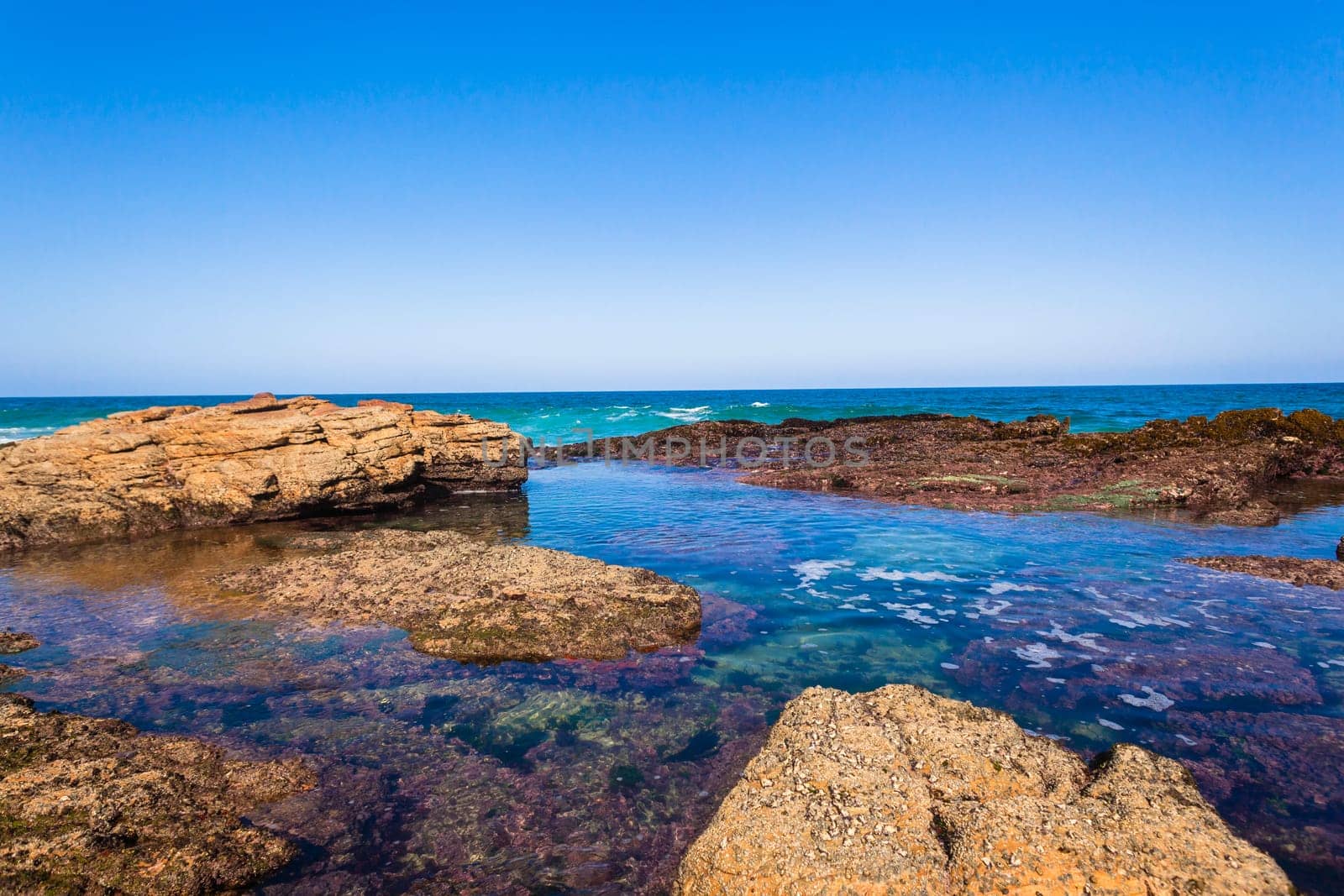 Ocean wave water into rocky coastline tide pools