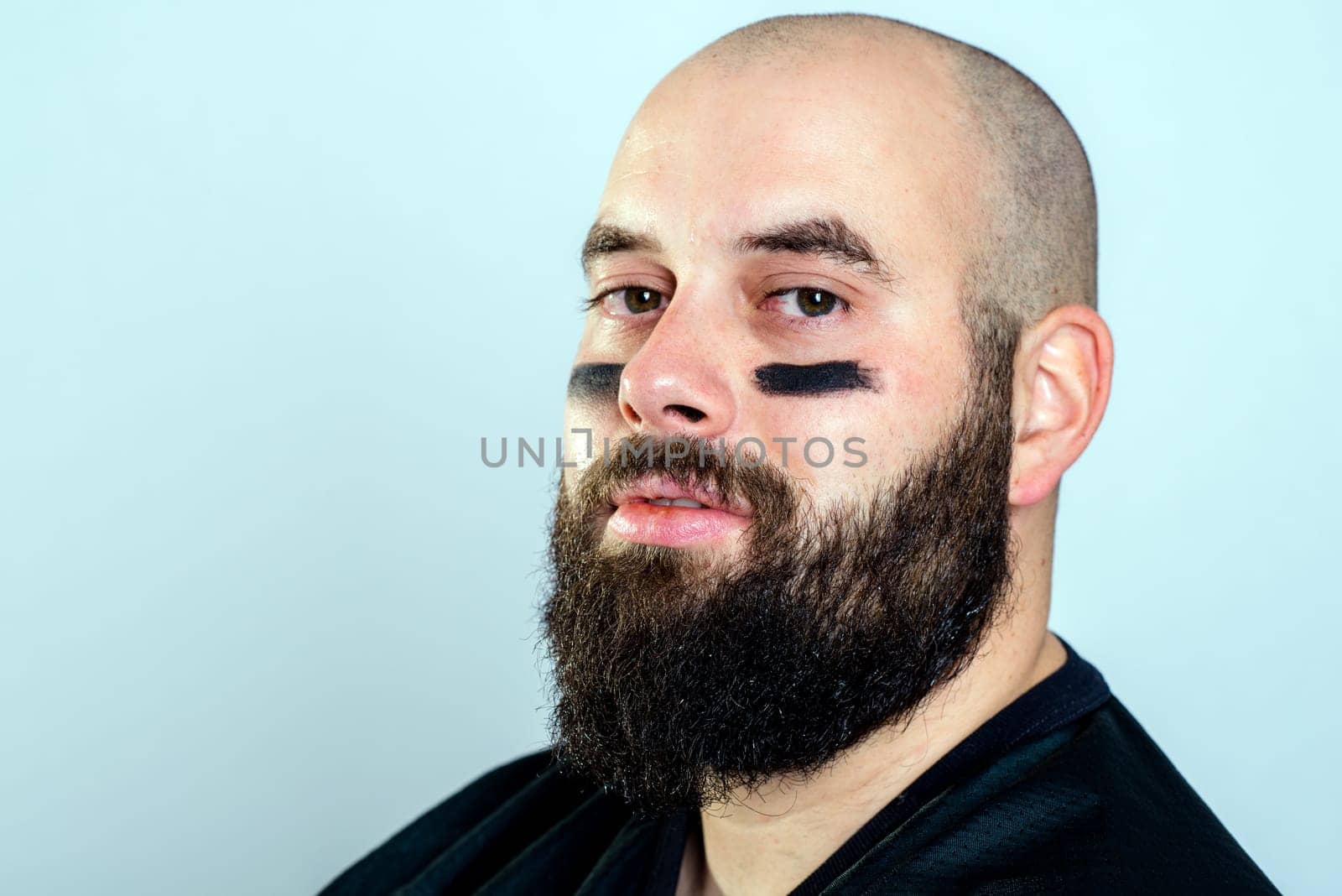 bearded american football player is looking in to the camera