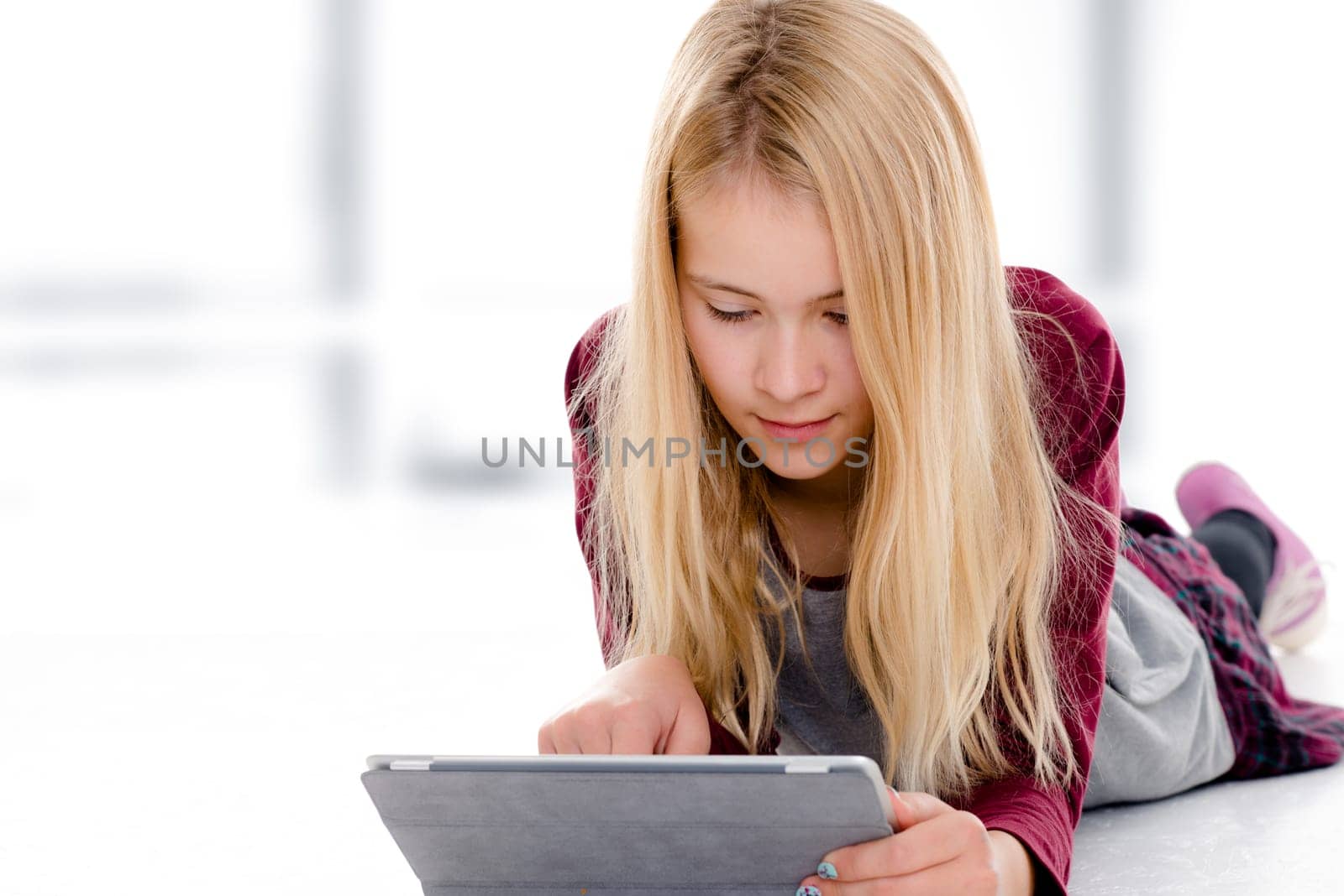 nice blond girl with tablet pc lying on the floor