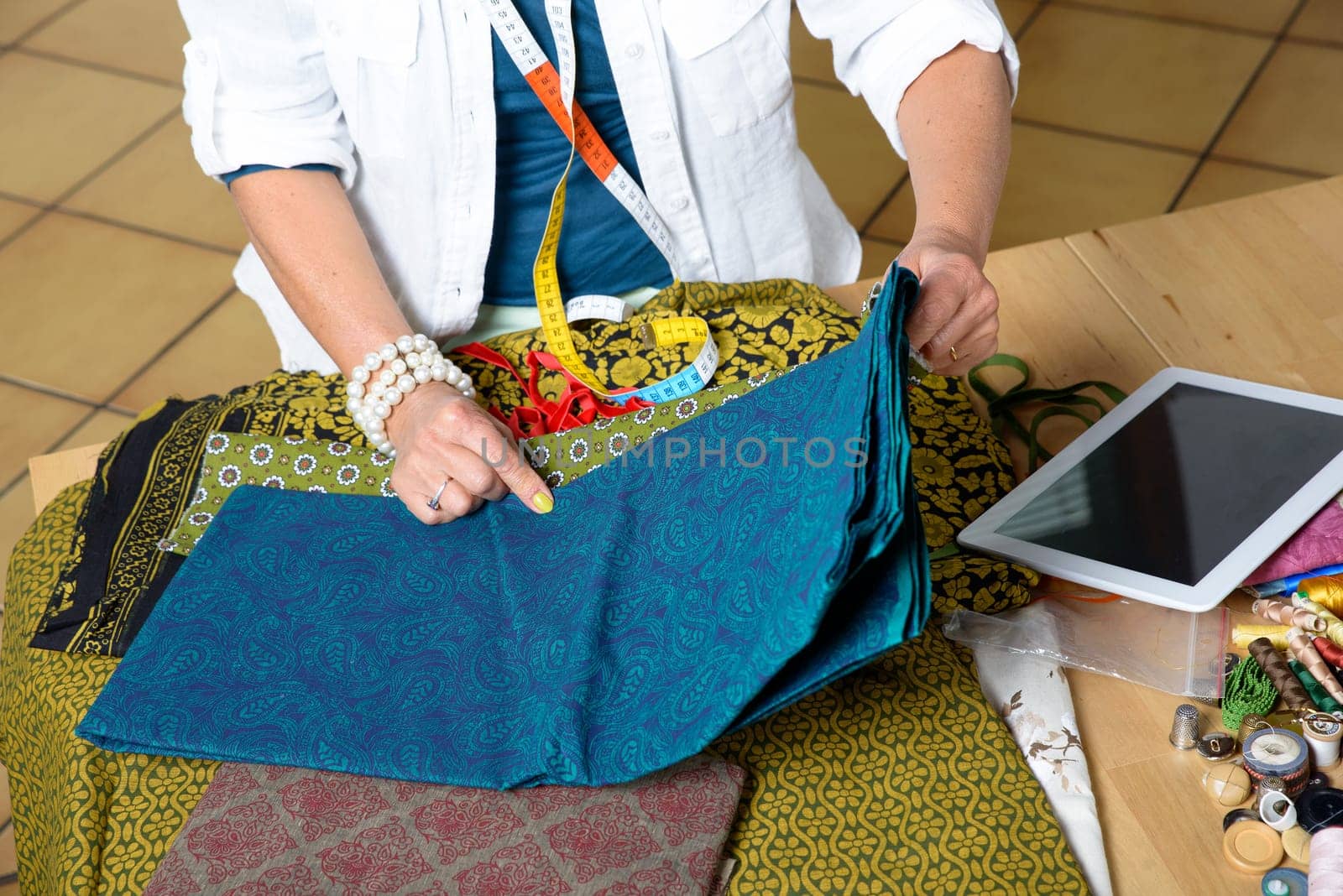 dressmaker look at a digital tablet in his workshop