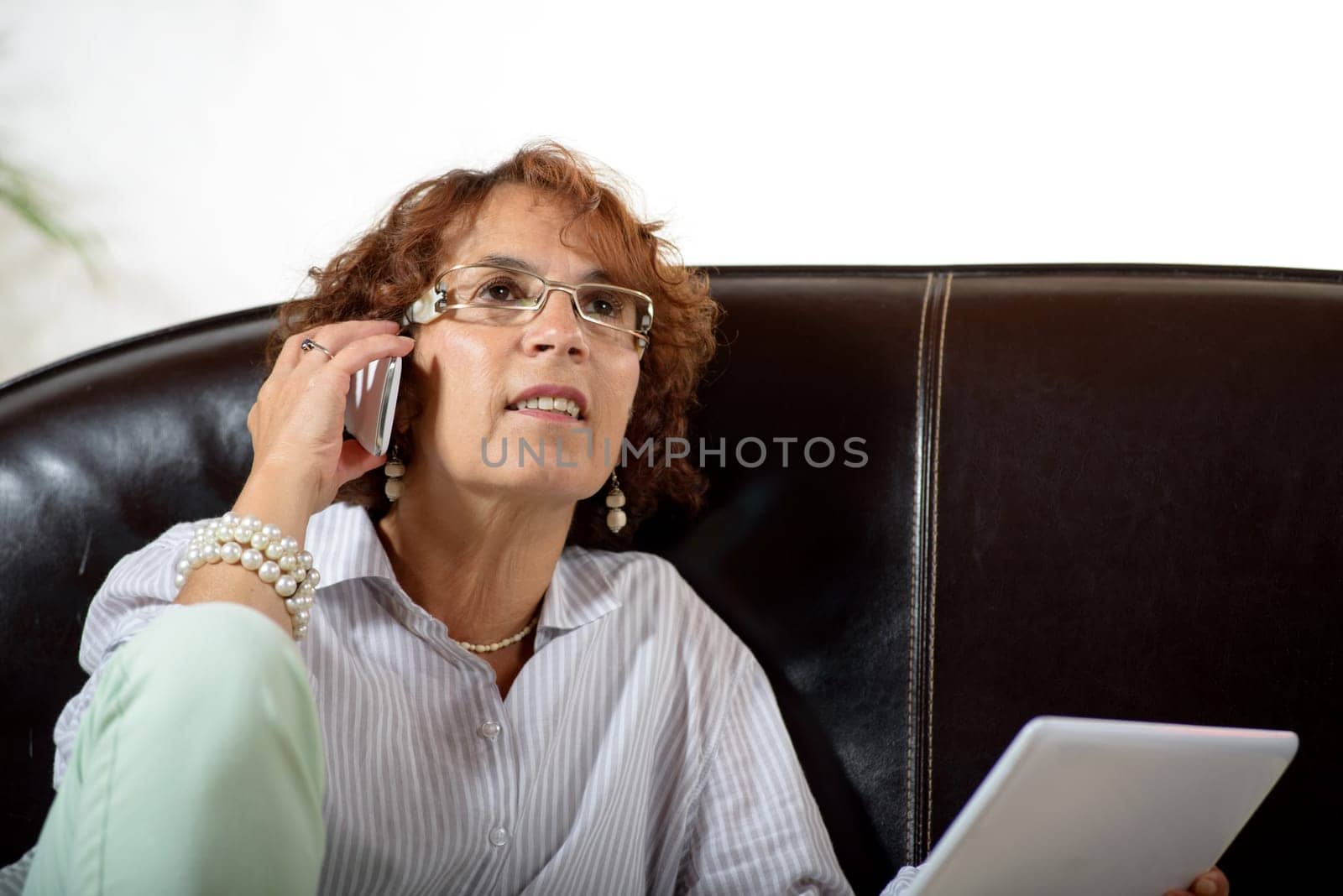 a senior woman in a sofa with a phone