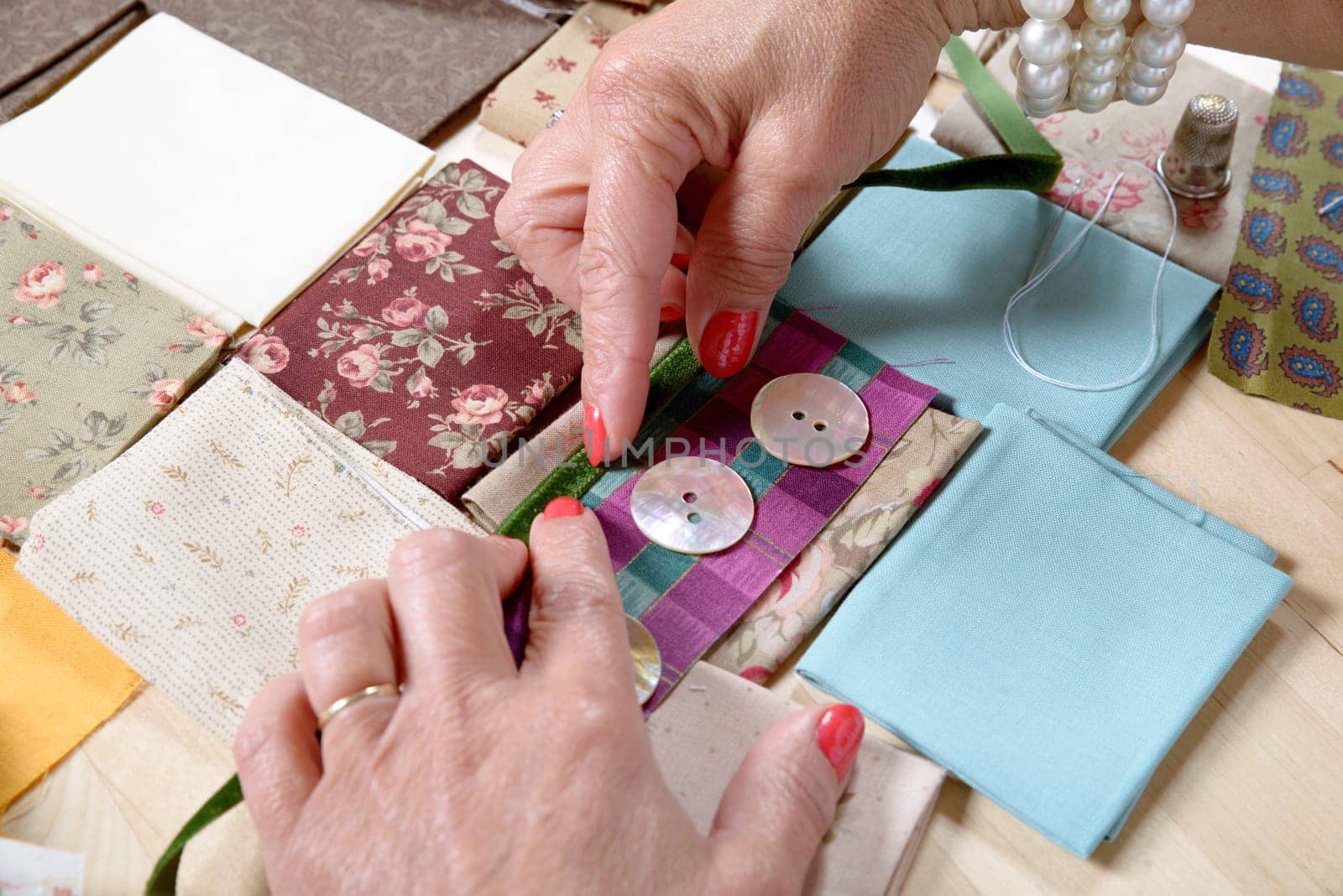 Close up of woman's hand sewing patchwork