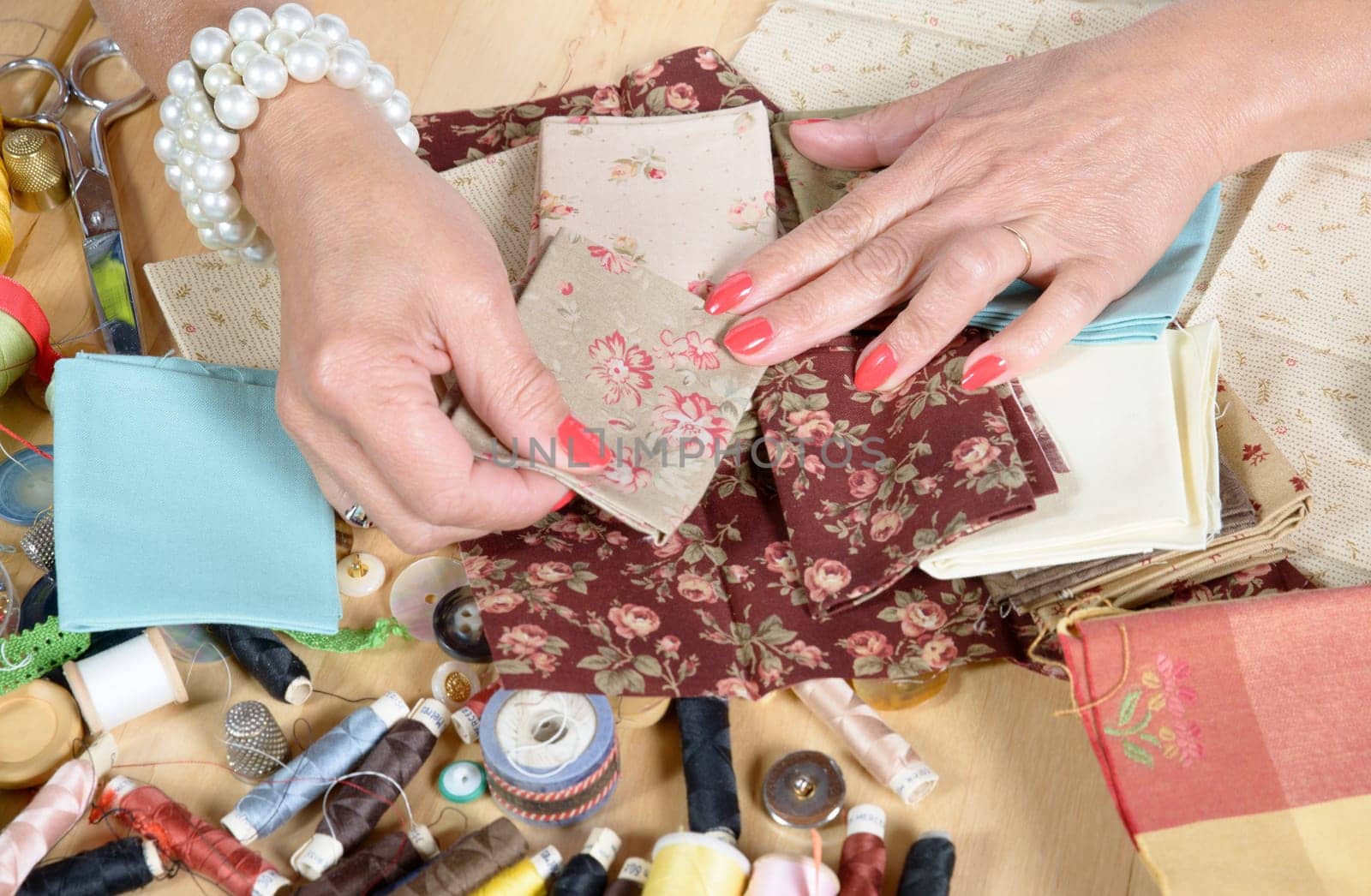 Close up of woman's hand sewing patchwork
