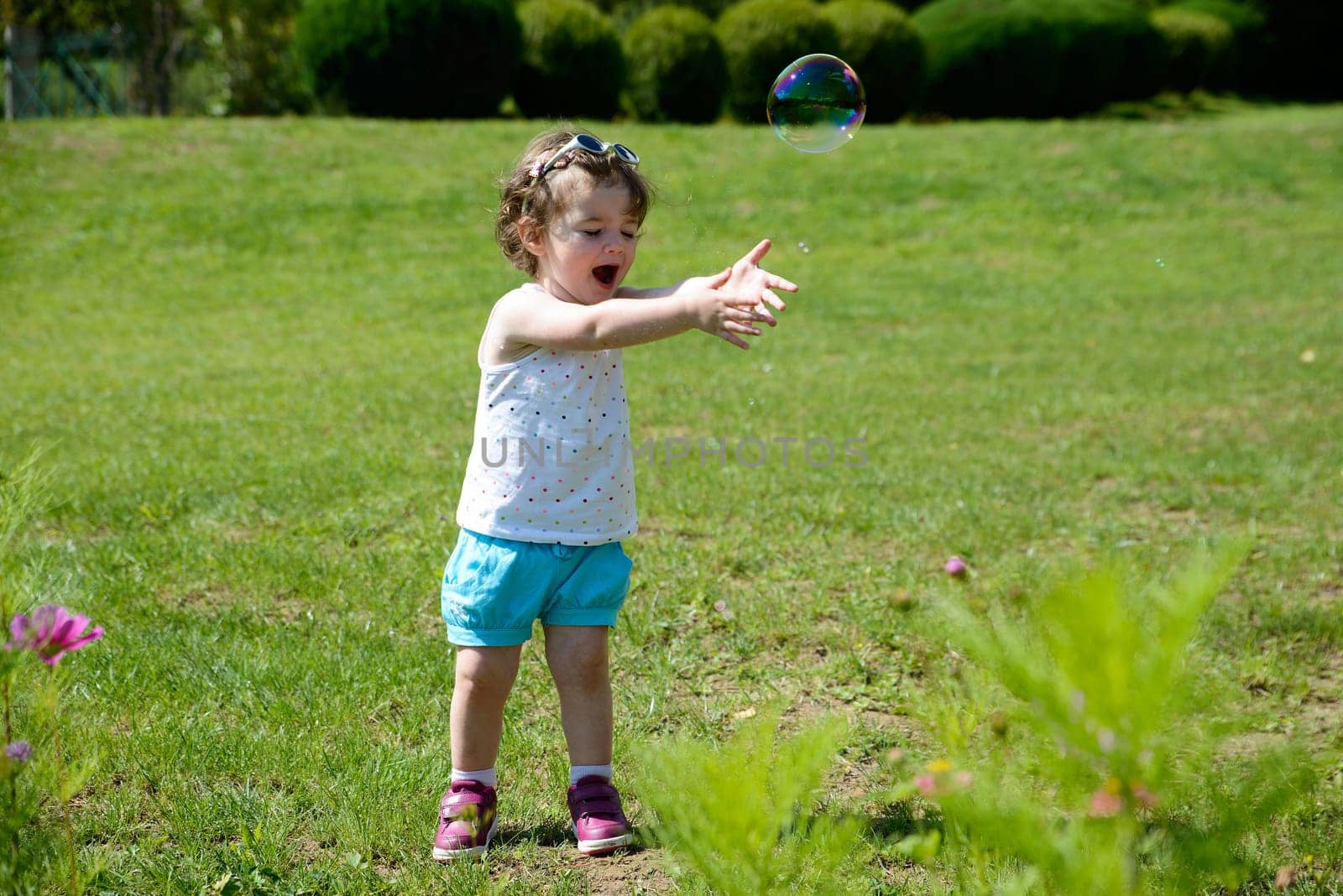 a little girl playing with soap bubbles