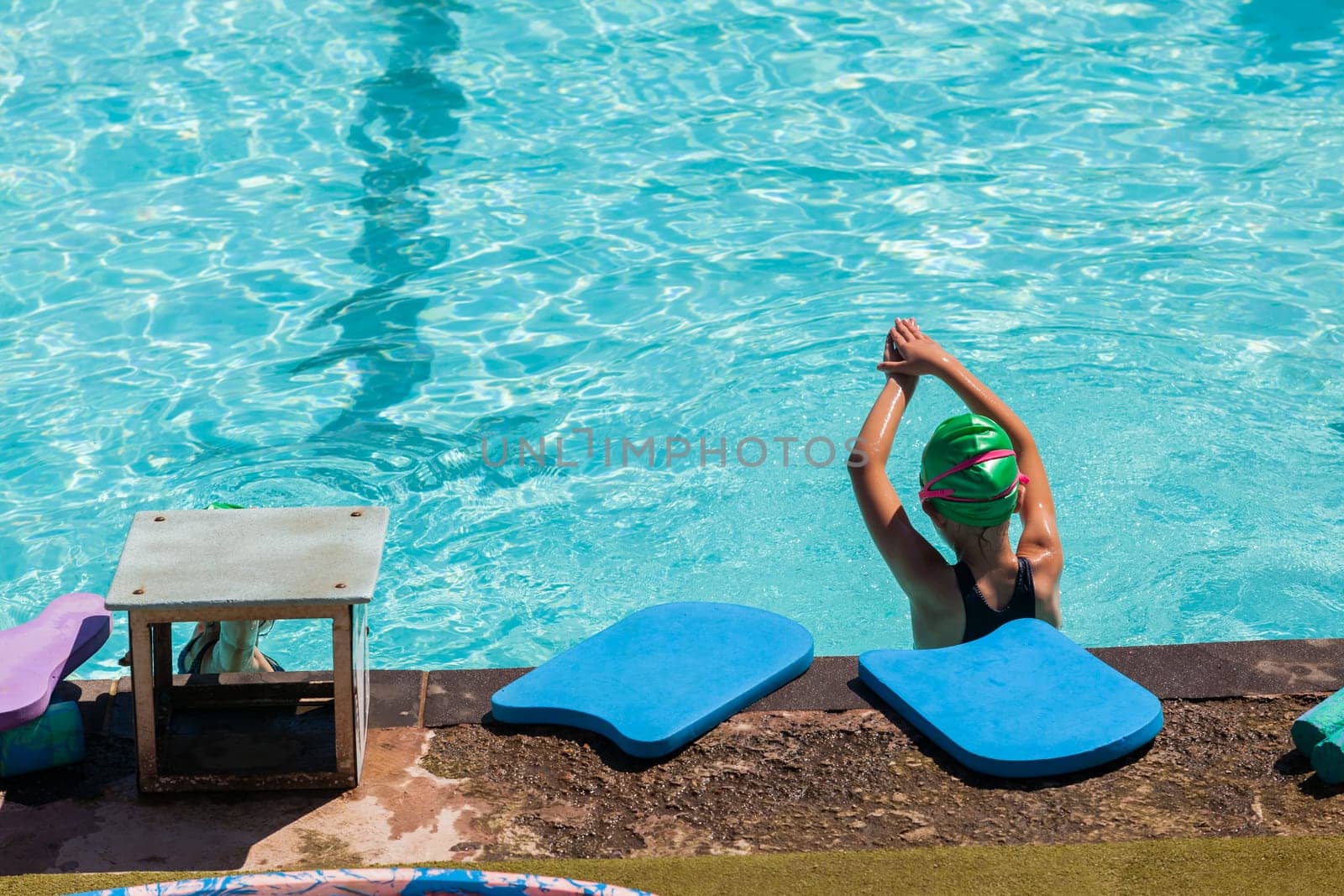 Young girl looks length of swimming pool lessons learning to swim challenges goals