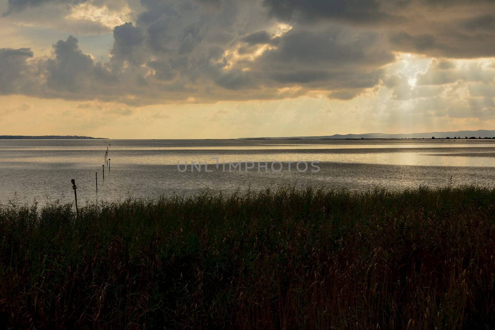 Sunset in the lagoon, where fishermen return to the approach of the impending storm. Dawning. Mediterranean islands.