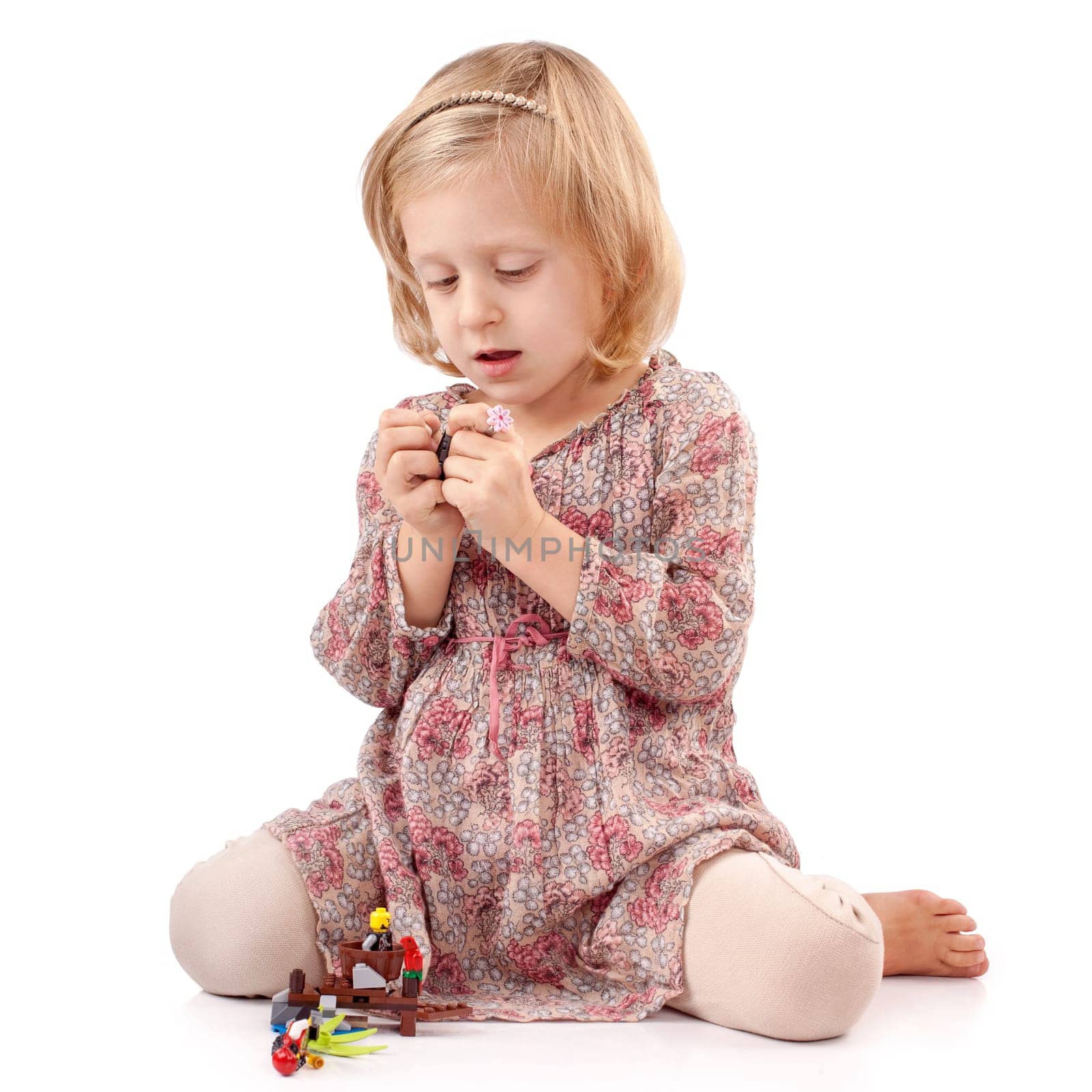 Very thoughtful girl playing with small toys