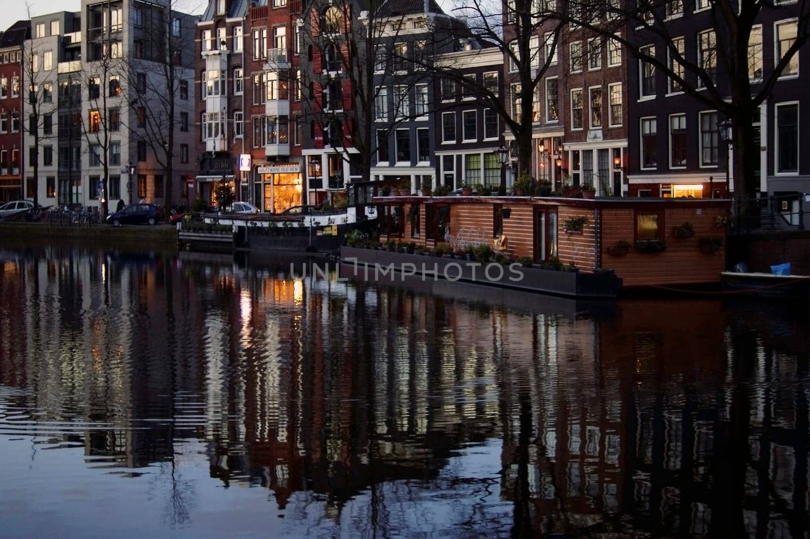 Amsterdam,Netherlands - December 29,2014: A canal or side canal in Amsterdam with colorful houses reflected in the water in the early morning of December 29,2014 in Amsterdam.
