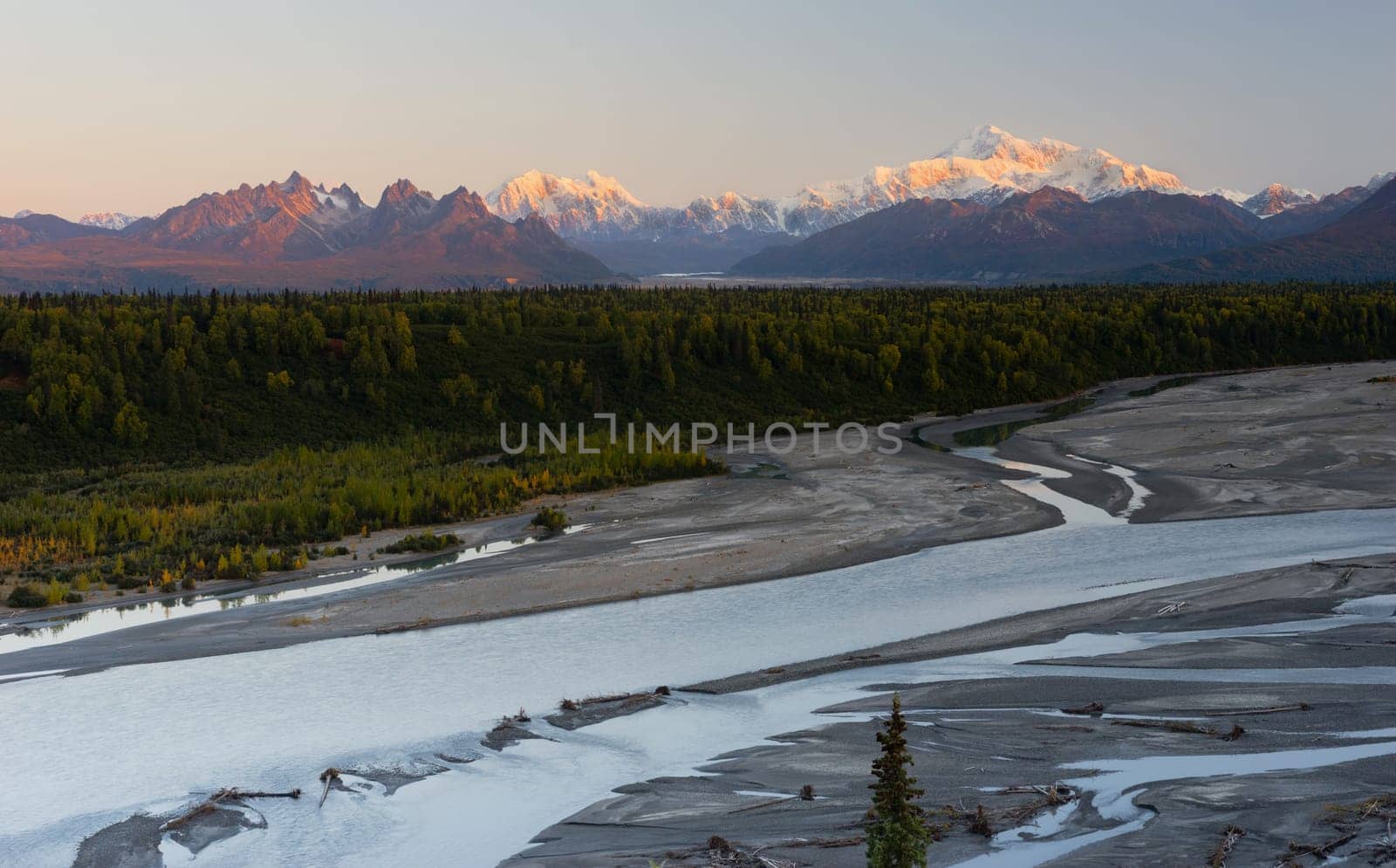The sun rise glows as it hits the tall peaks in the Denali Mountain Range