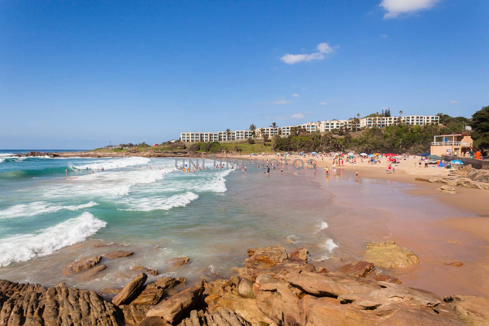 Ocean waves swimmers men women boys girls  in beach rocky landscape