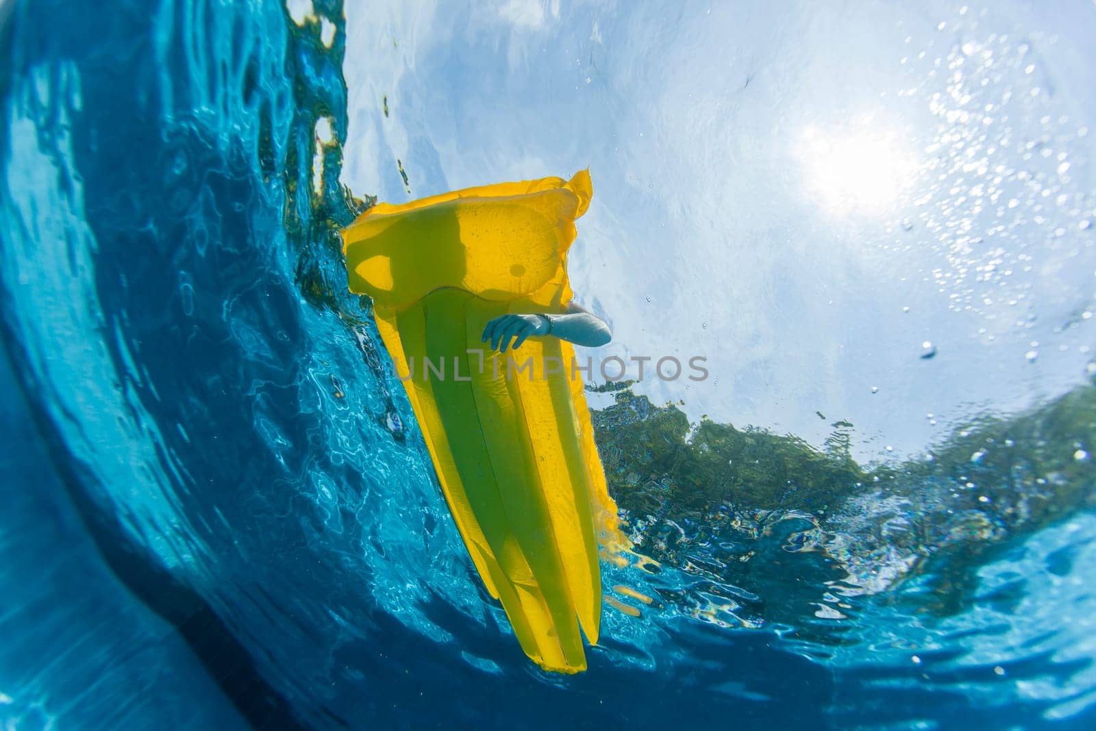 Underwater upward of girl on air-matt sunbathing swimming pool home solitude.