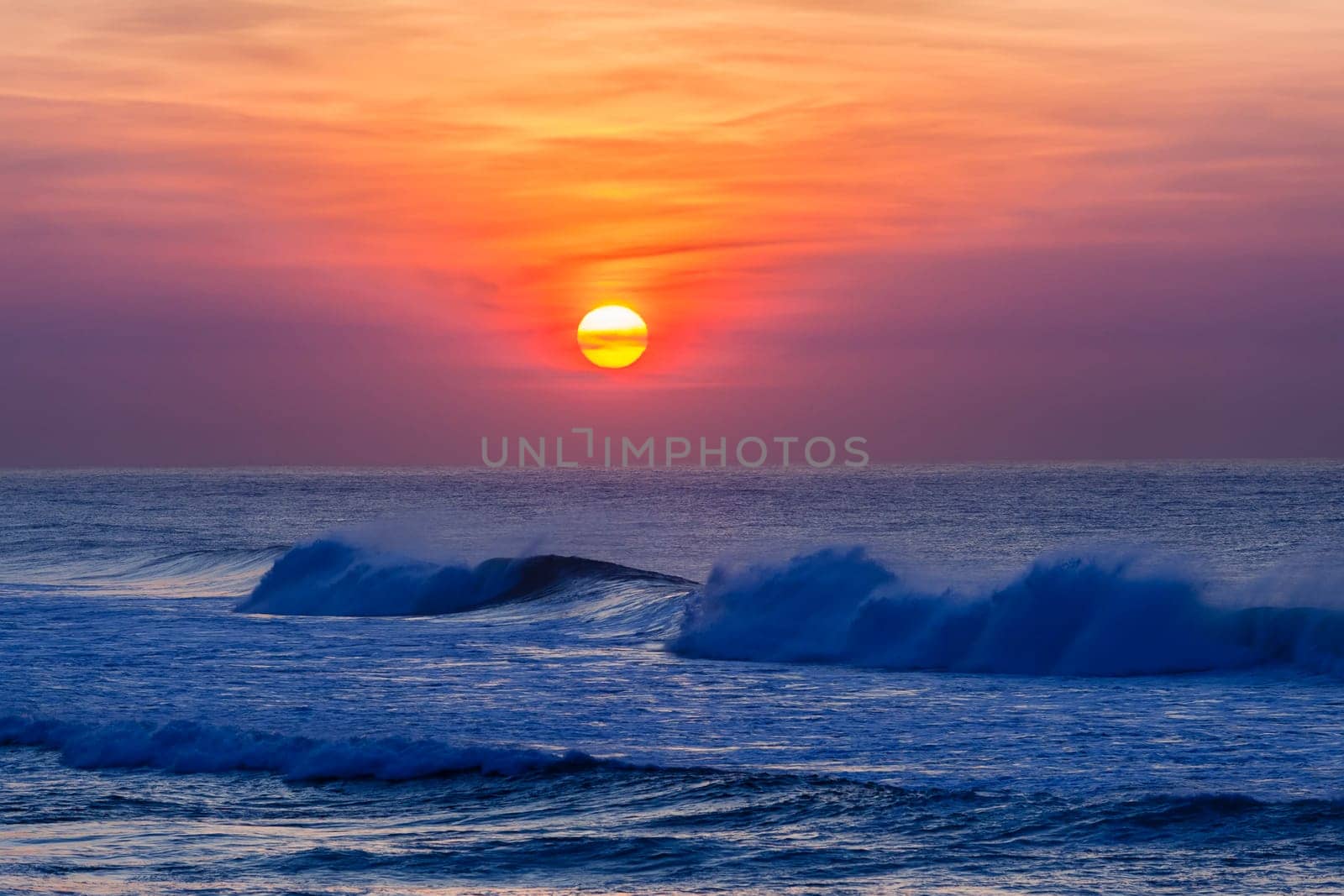 Beach ocean waves with sunrise on horizon water