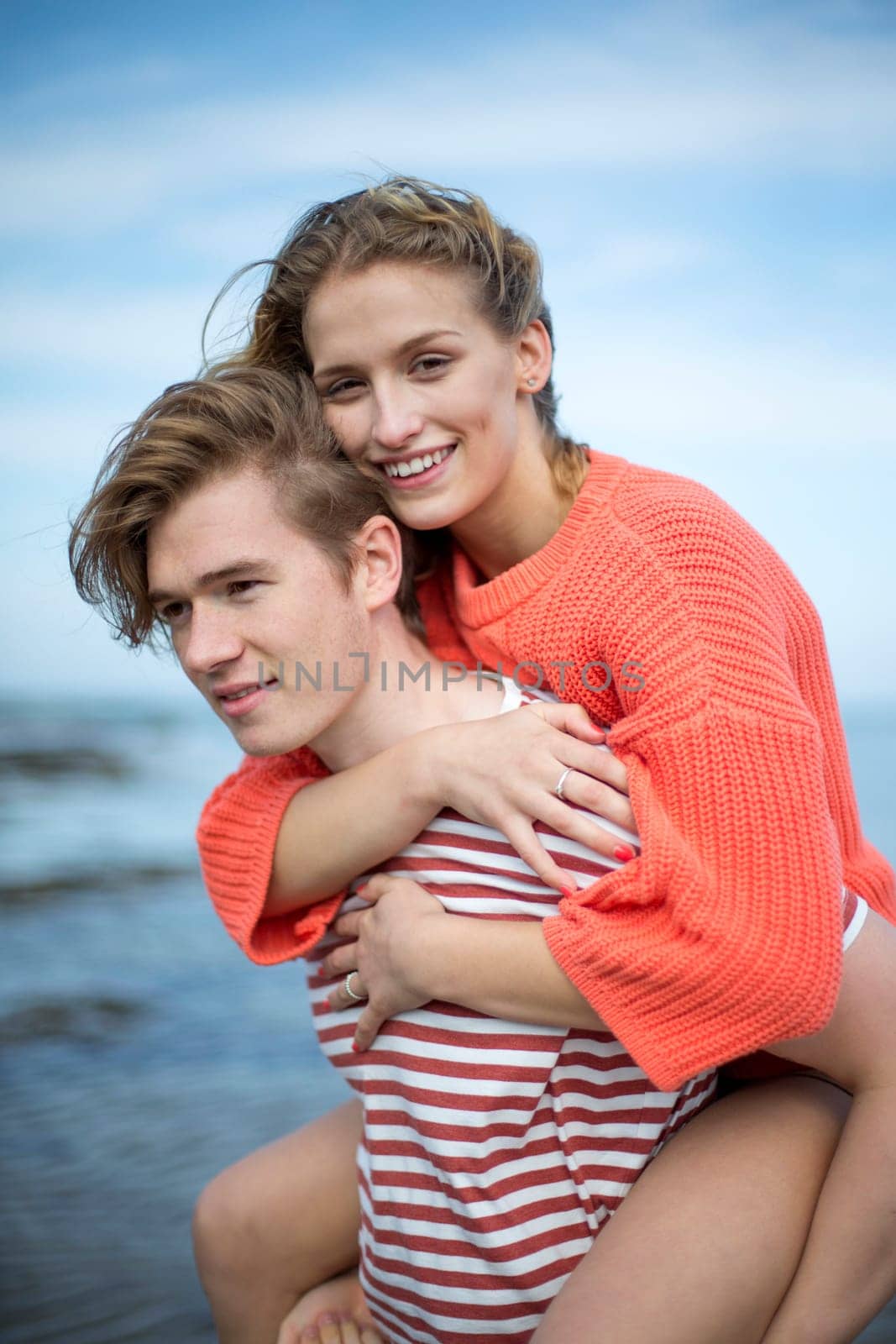 Portrait of a beautiful affectionate young couple at the beach. They look very content and happy together.