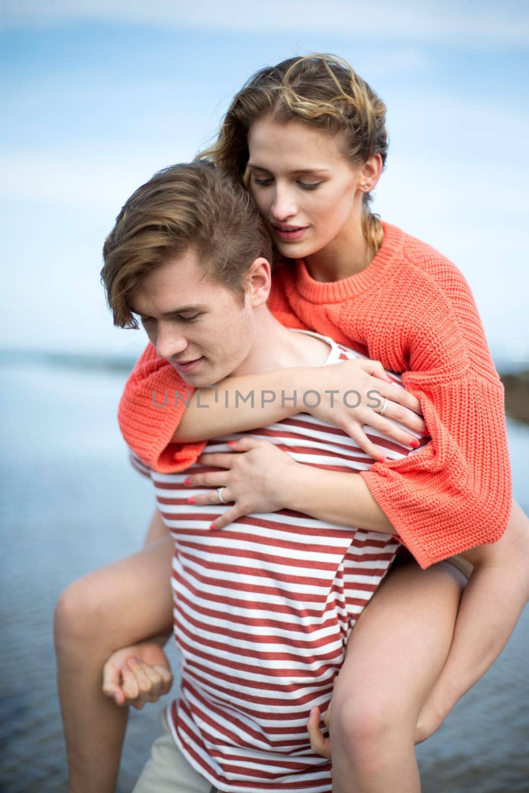 Beautiful young couple at the beach. They look very content and happy together.