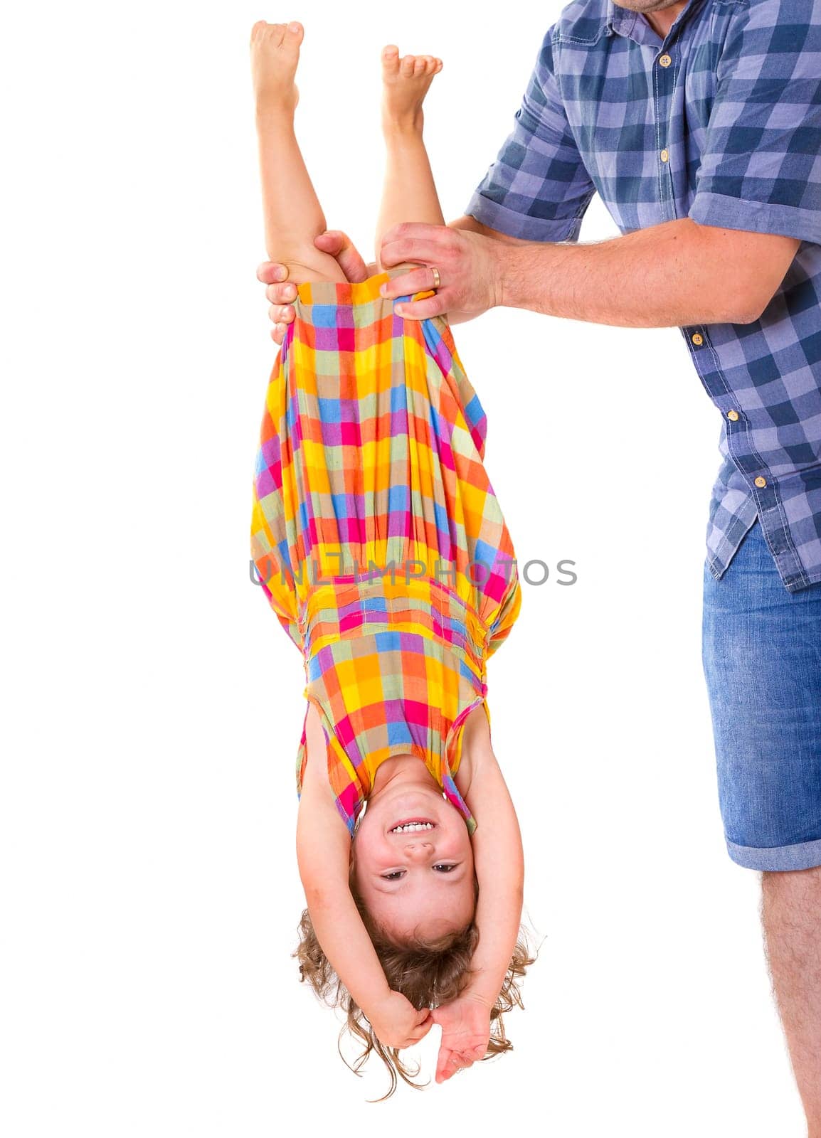 Father holding his little daughter upside down. Trust concept.