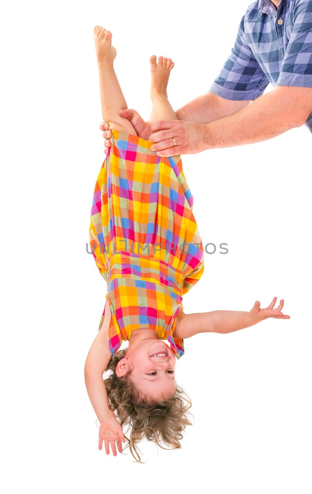 Father holding his little daughter upside down. Trust concept.