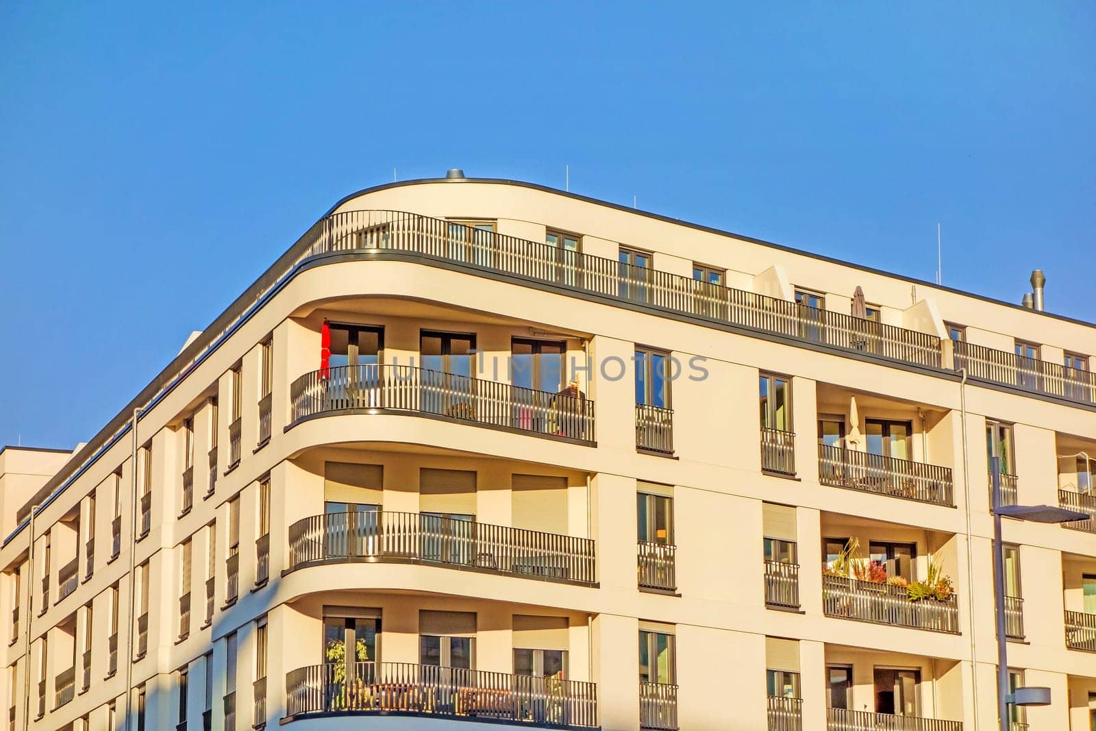 Apartment building facade with balconies, urban - blue sky