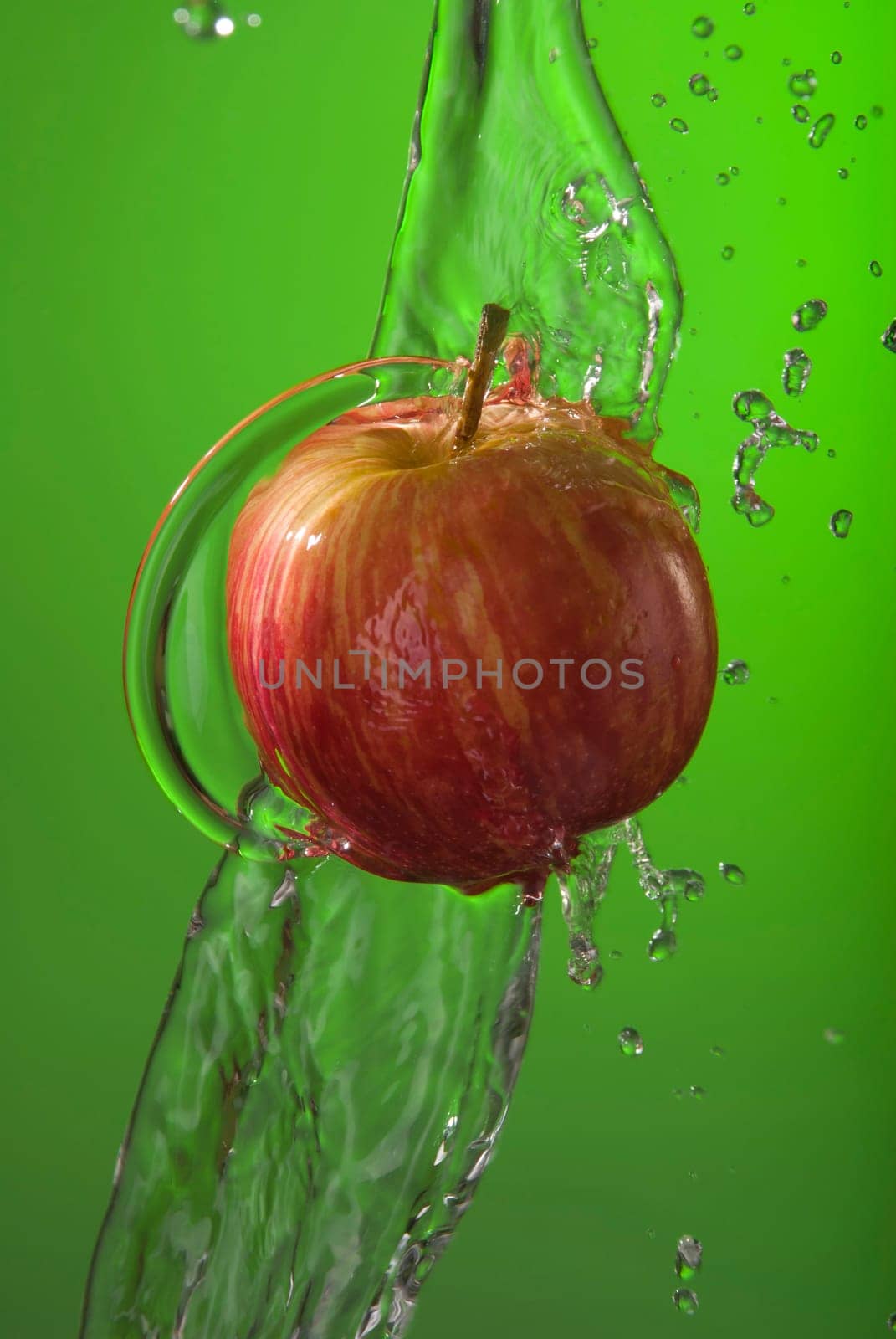 Delicious organic red apple fruit on green background with water splash motion. Ideal for health campaign or poster.