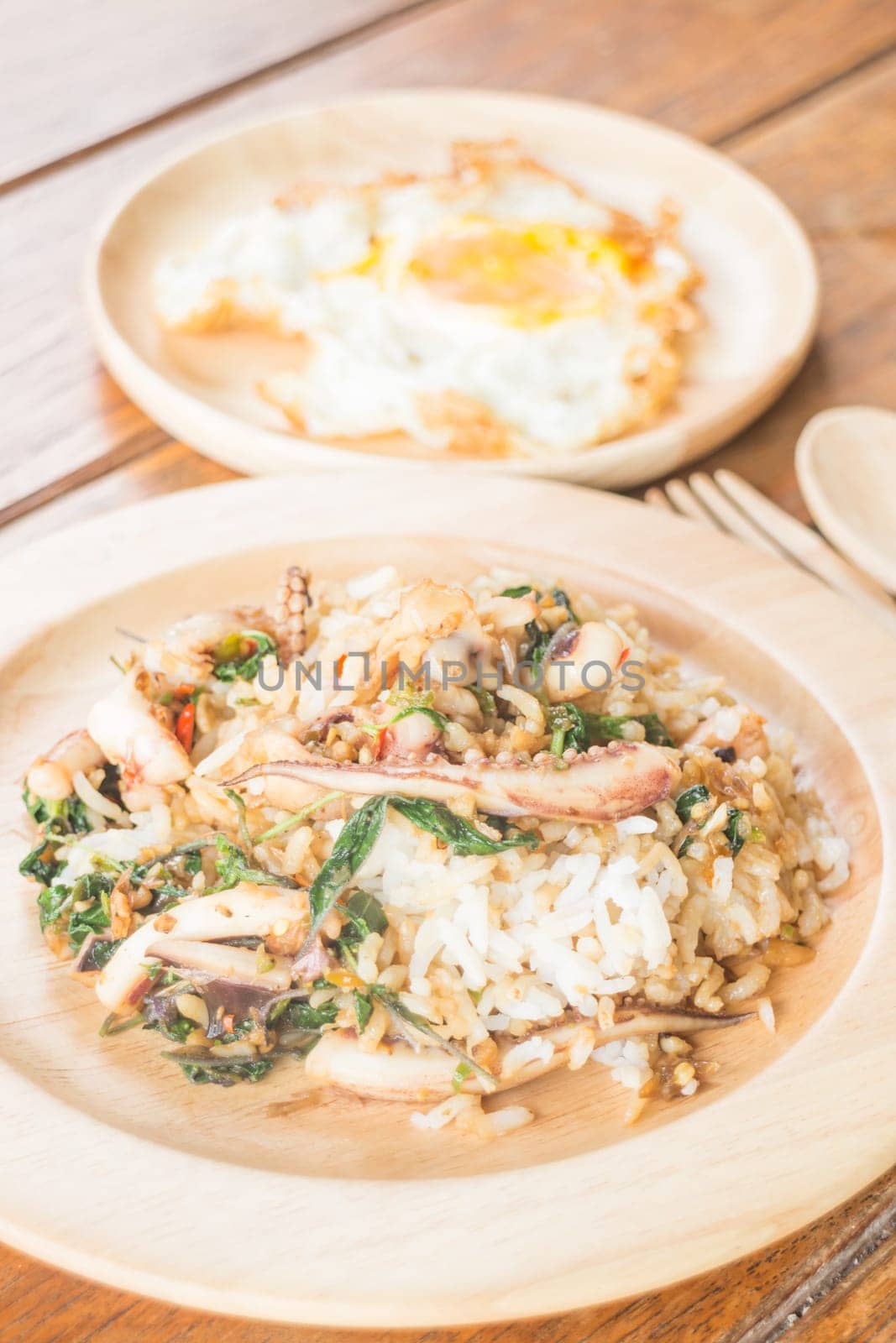 Rice topped with stir-fried squid basil and fried egg (Thai food), stock photo