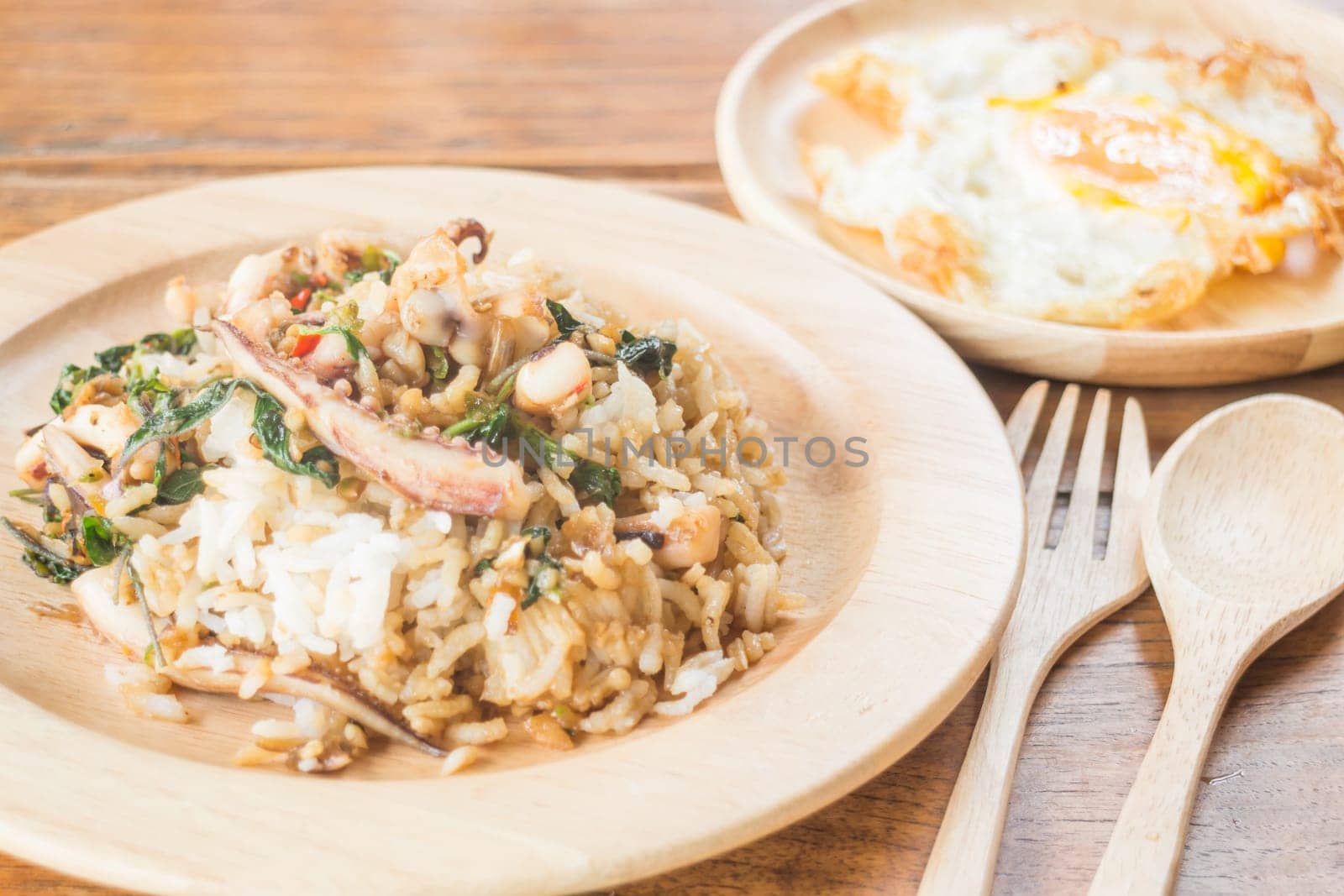 Rice topped with stir-fried squid basil and fried egg (Thai food), stock photo