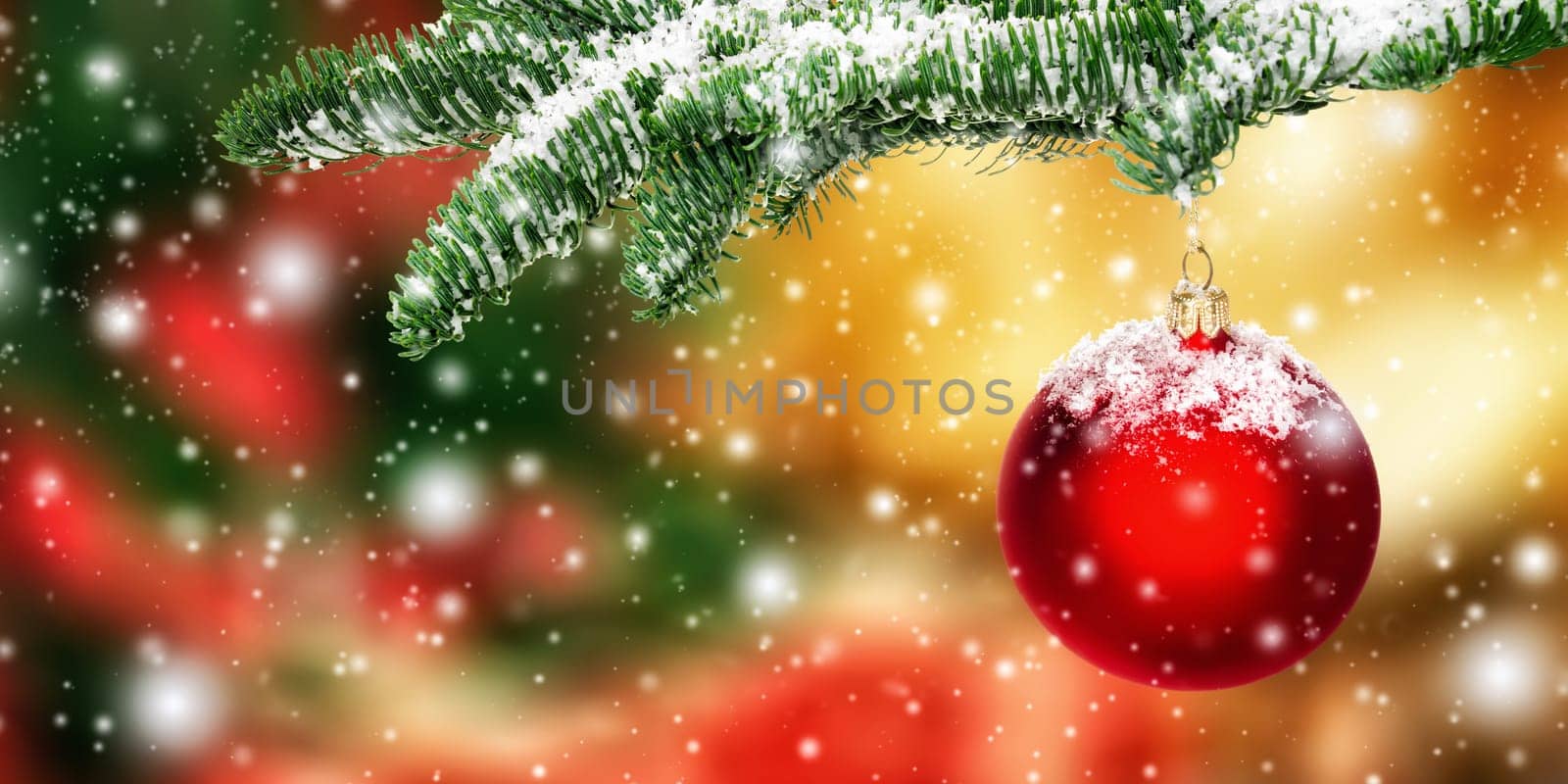 Red Christmas bauble in snow hanging from a fir branch,with colorful blurred background