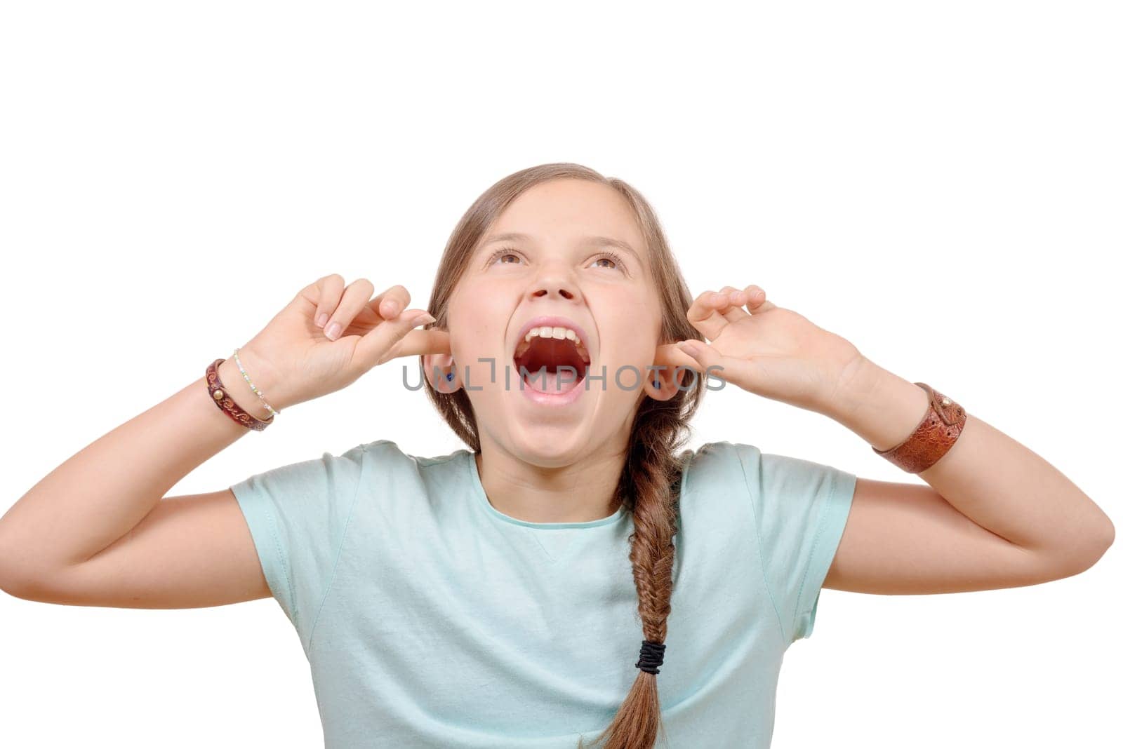 A young girl covers ears with hands on white background