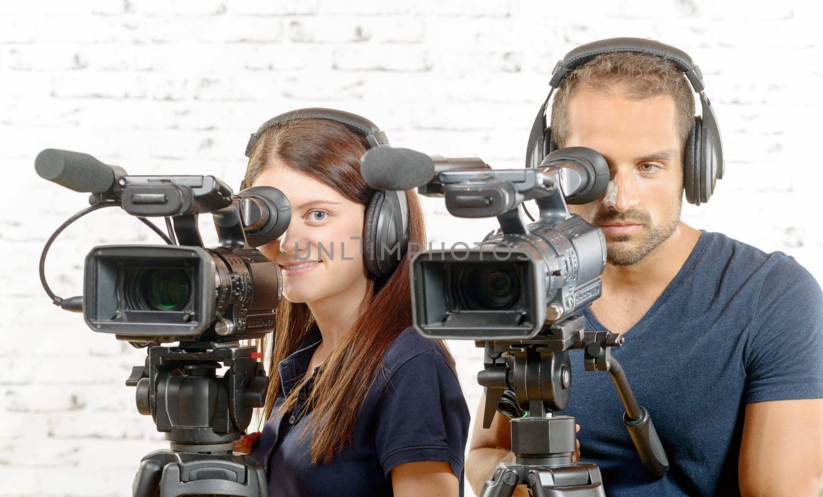 a young man and a young woman with professional video cameras