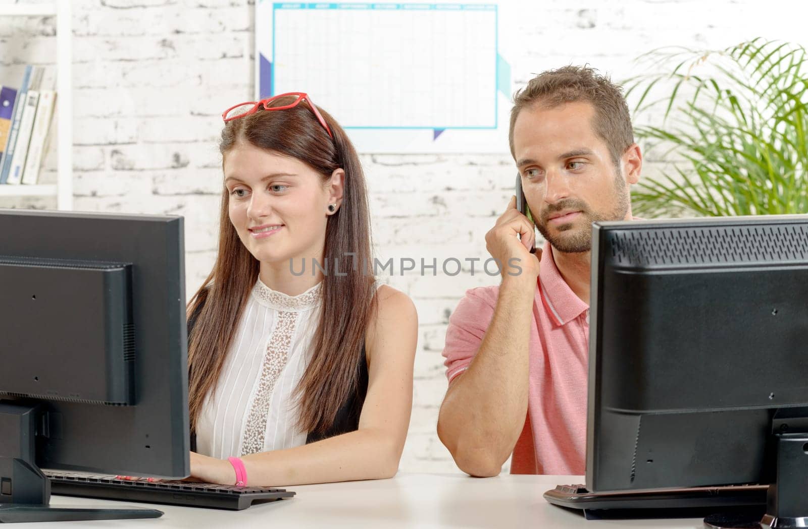 Couple at work in the office, man on phone