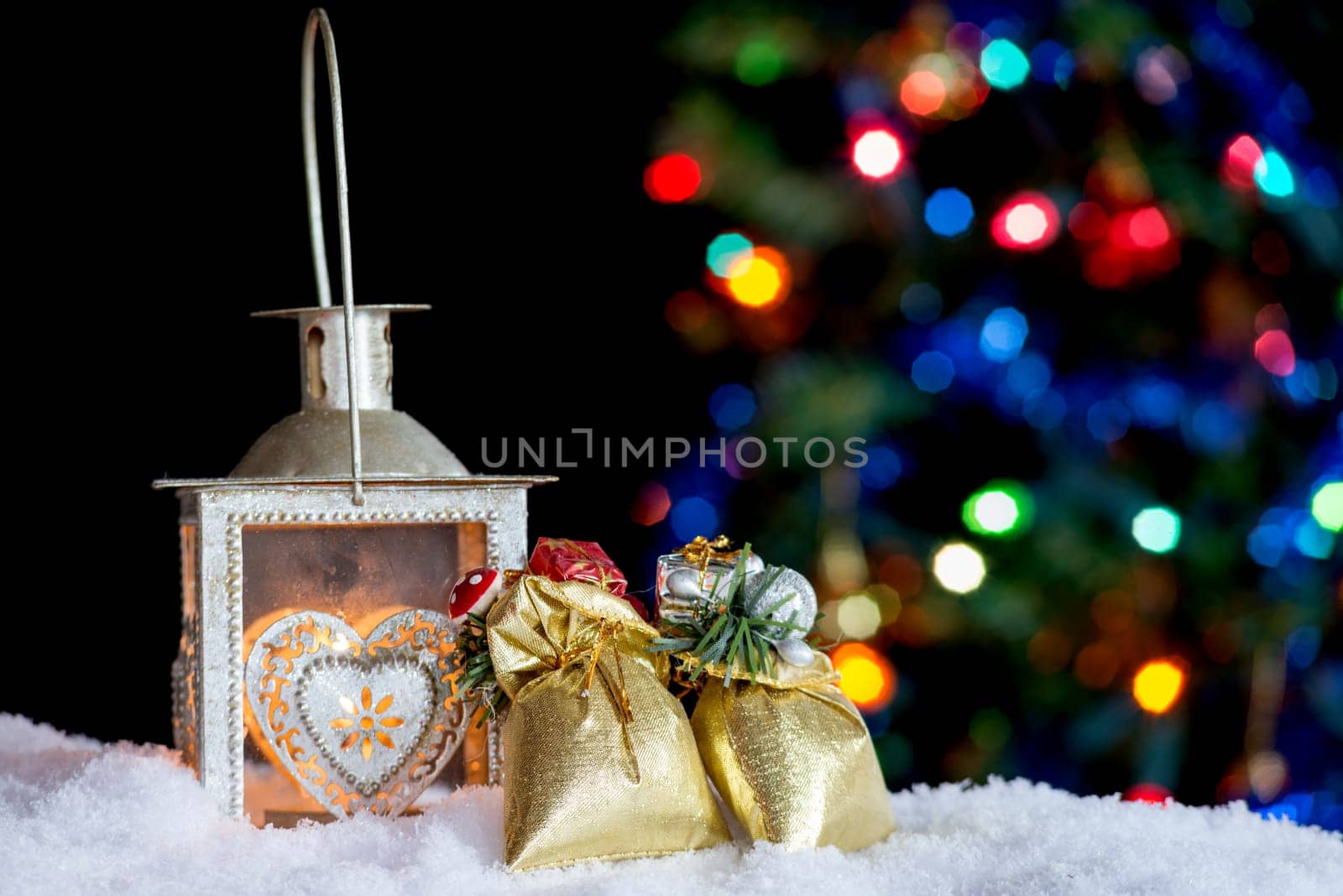 Christmas background with burning lantern in the snow and bokeh