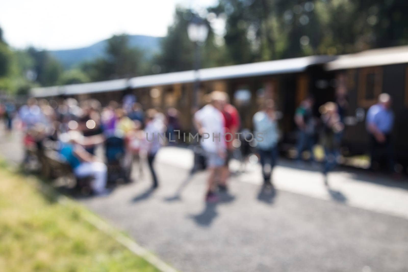 out of focus shot of passengers at a trainstation, entering and leaving the train, shot in summertime