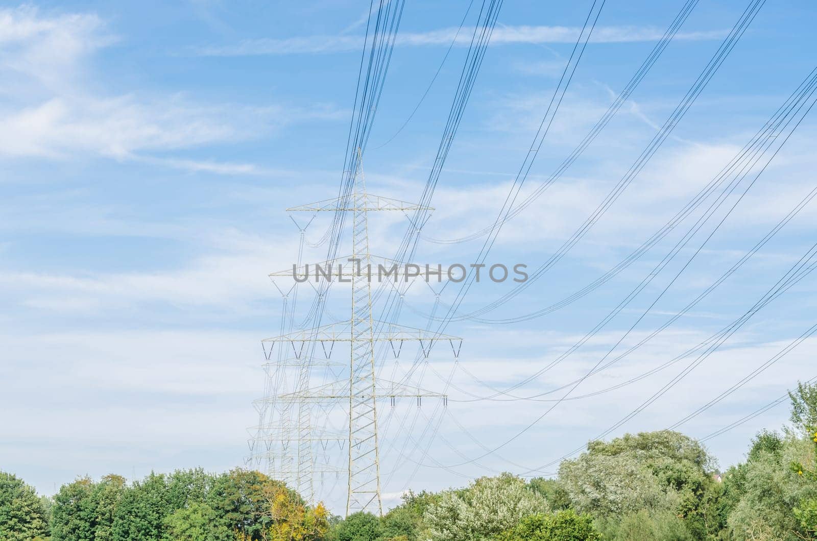 High voltage towers with blue skies in the background.