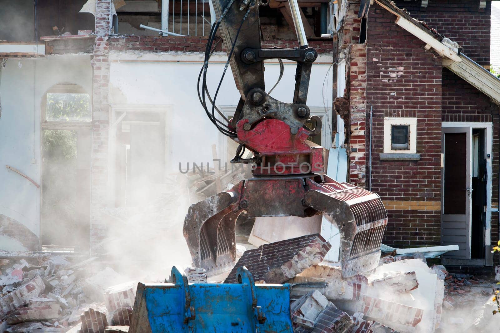 Demolishing an abandoned house with a grab